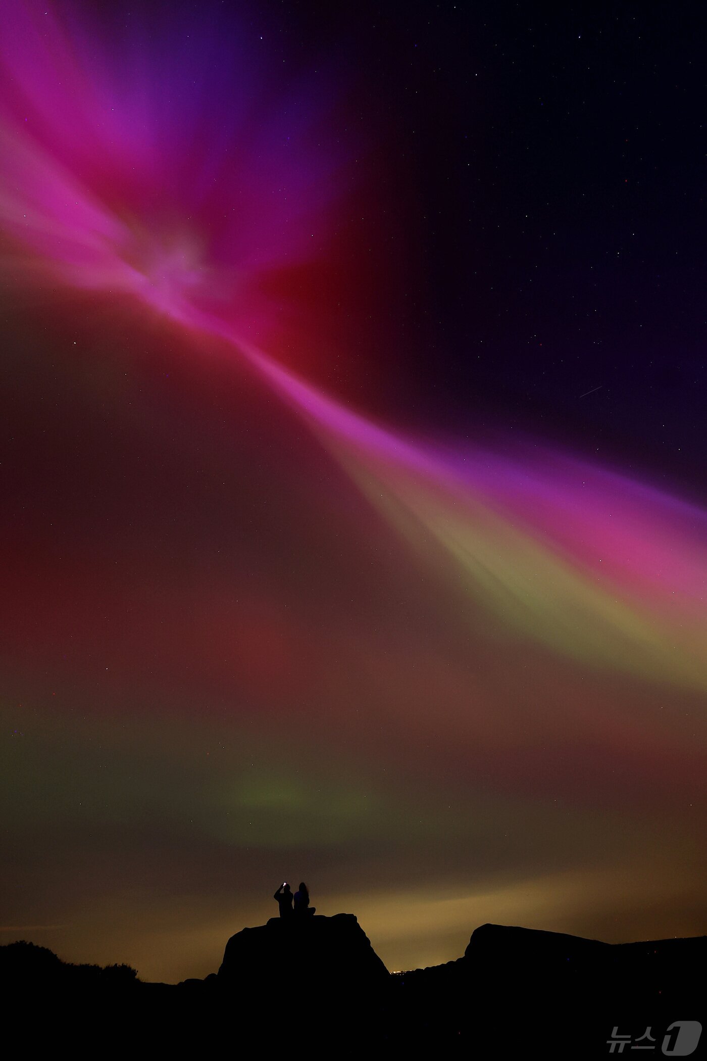 본문 이미지 - 영국 중서부 스태퍼드셔주 리크 근처의 더 로치스 상공에서 '오로라'가 보인다. 2024.5.10 ⓒ 로이터=뉴스1 