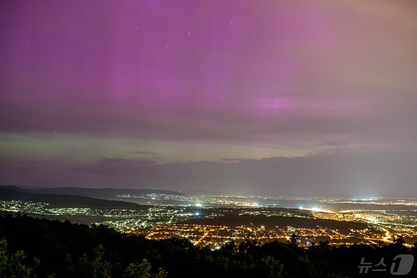 본문 이미지 - 헝가리 부다페스트의 하르마샤타르 언덕에서 우롬과 필리스보로스제노 상공에 오로라가 보이고 있다. 2024.5.11 ⓒ 로이터=뉴스1 