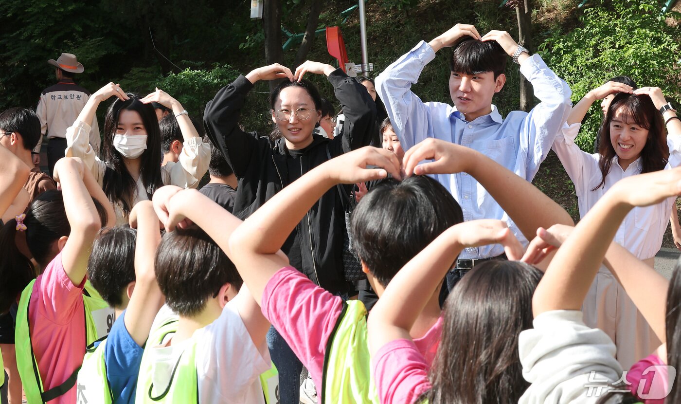 본문 이미지 - 스승의 날을 하루 앞둔 14일 서울 서초구 원명초등학교에서 학생들이 선생님을 향해 하트를 그리고 있다. 2024.5.14/뉴스1 ⓒ News1 김성진 기자