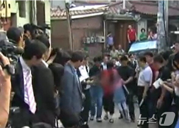 본문 이미지 -  2010년 6월 15일 현장검증에서 김수철이 피해자를 위협해 끌고 가는 모습을 재현하고 있다. (SBS 갈무리) ⓒ 뉴스1