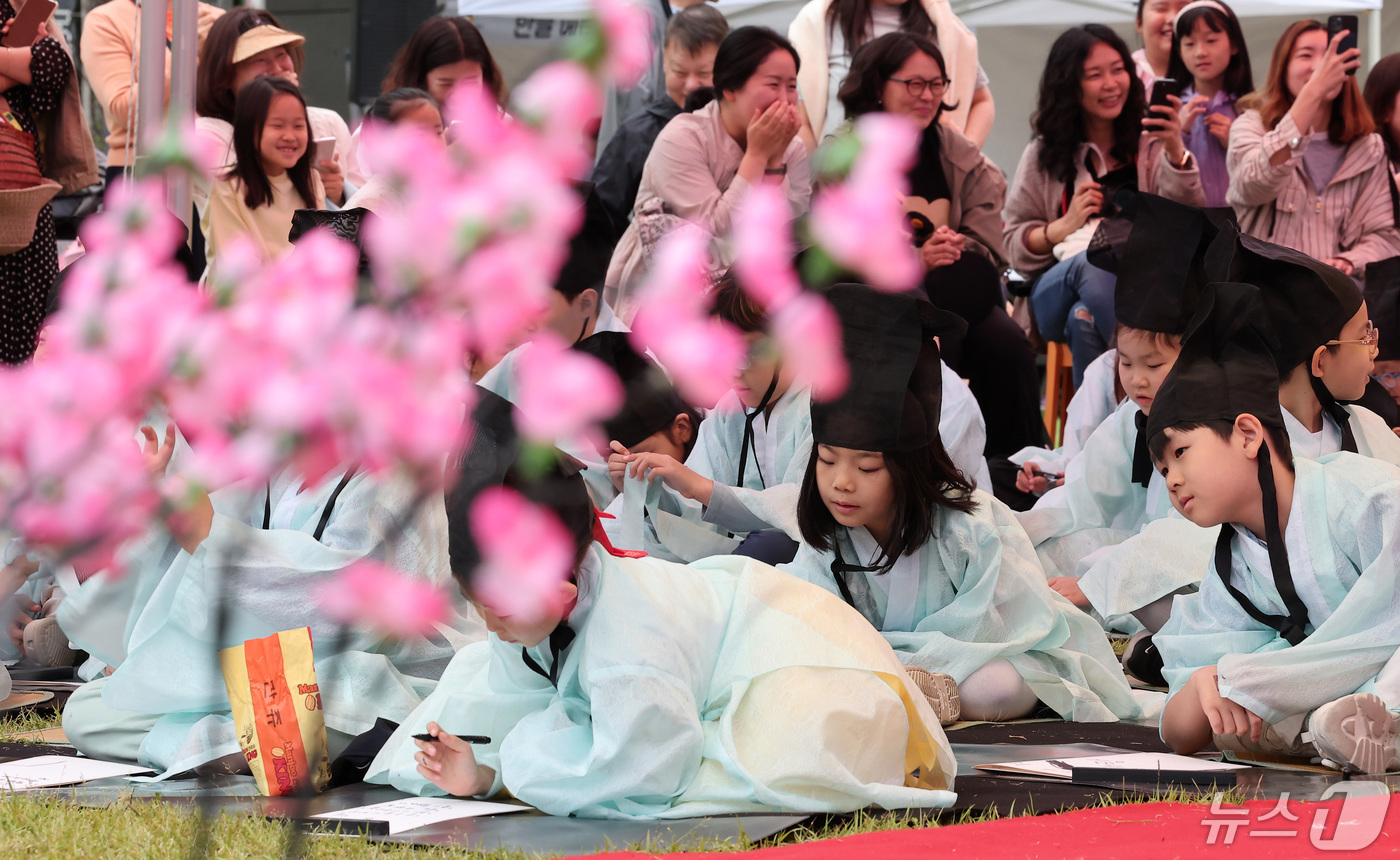 (서울=뉴스1) 김성진 기자 = 15일 서울 용산구 국립한글박물관에서 열린 2024년 국립한글박물관 제627돌 세종대왕 나신 날 기념행사에서 도포와 유건을 착용한 학생들이 과거시험 …
