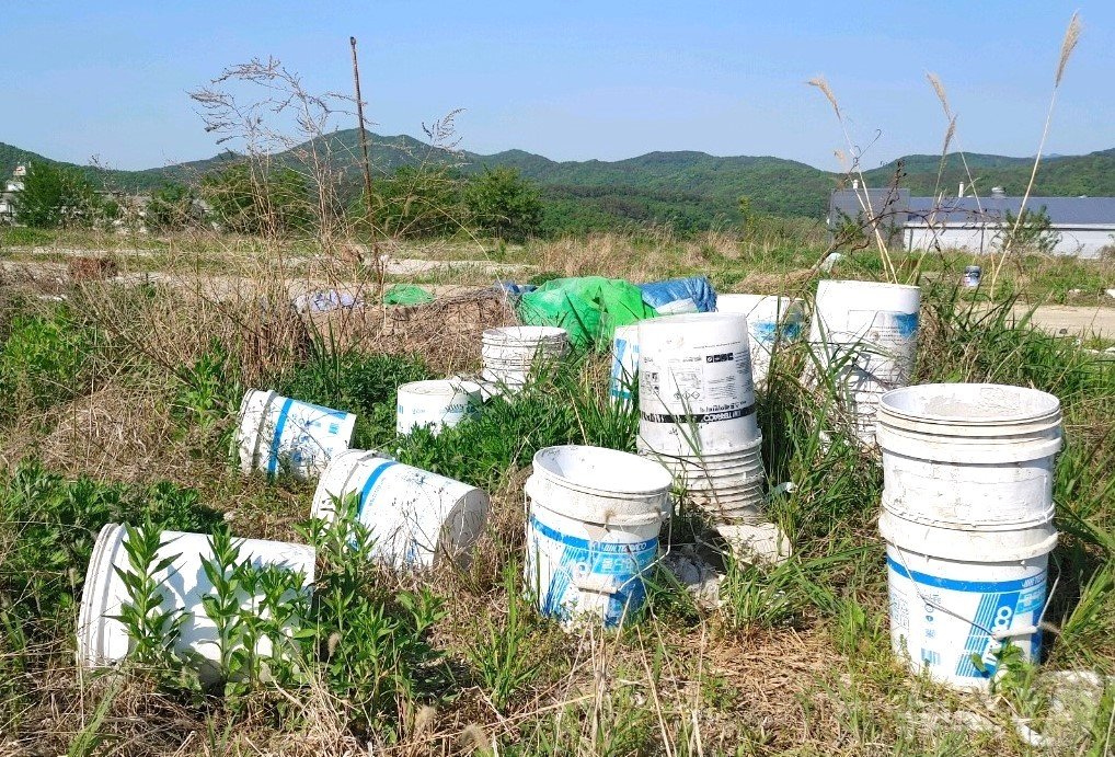본문 이미지 - 충북 영동군 용산면 소재 영동산업단지 내 빈터에 수십여개 몰탈접착증가제 통이 방치돼 있다. /뉴스1