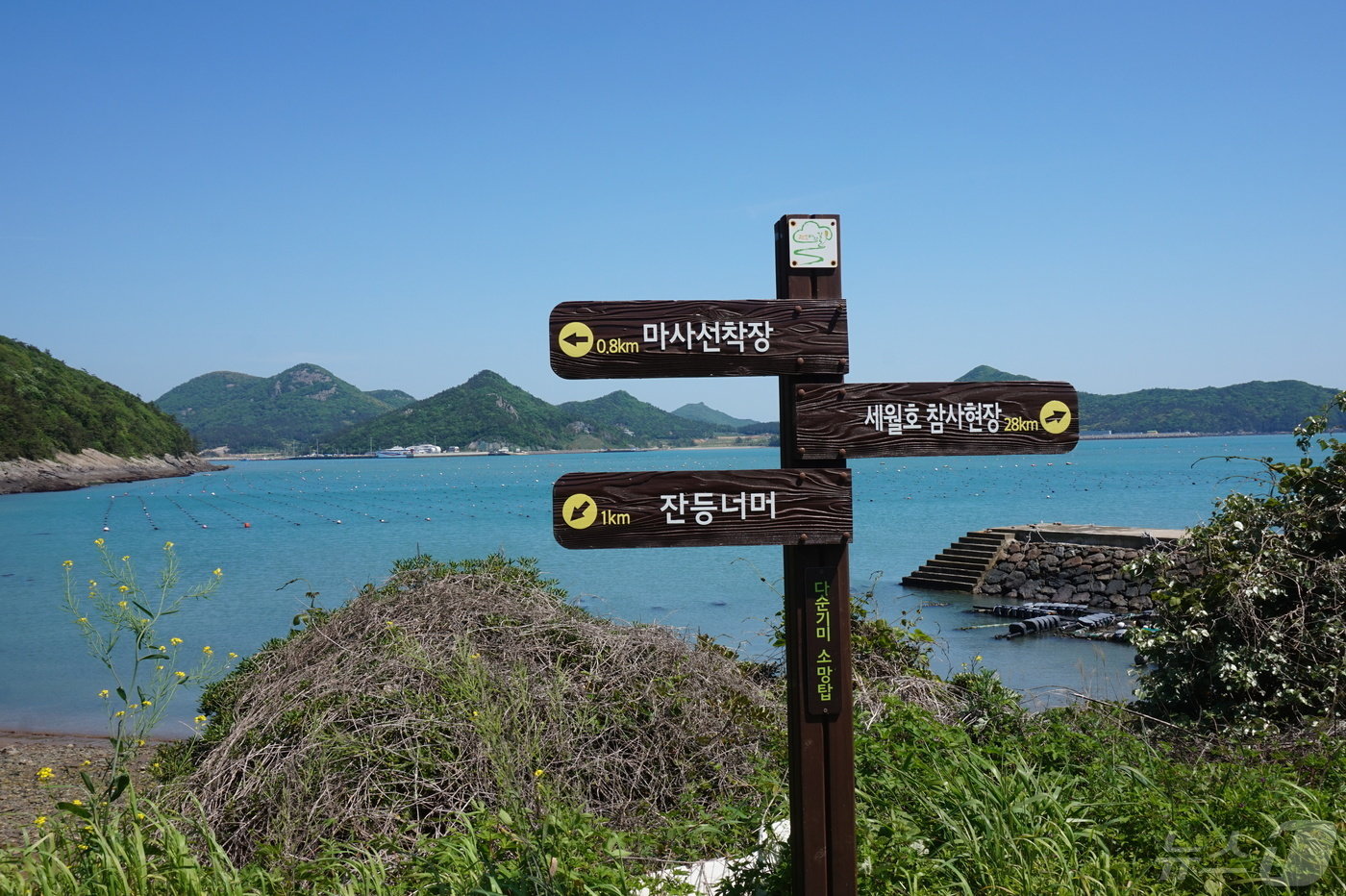 본문 이미지 - &#39;다순기기 소망탑&#39;의 &#39;팽목바람길&#39; 이정목. 바다건너 정면으로 팽목항이 까마득하다. 2024.5.17./뉴스1 ⓒ News1 조영석 기자 