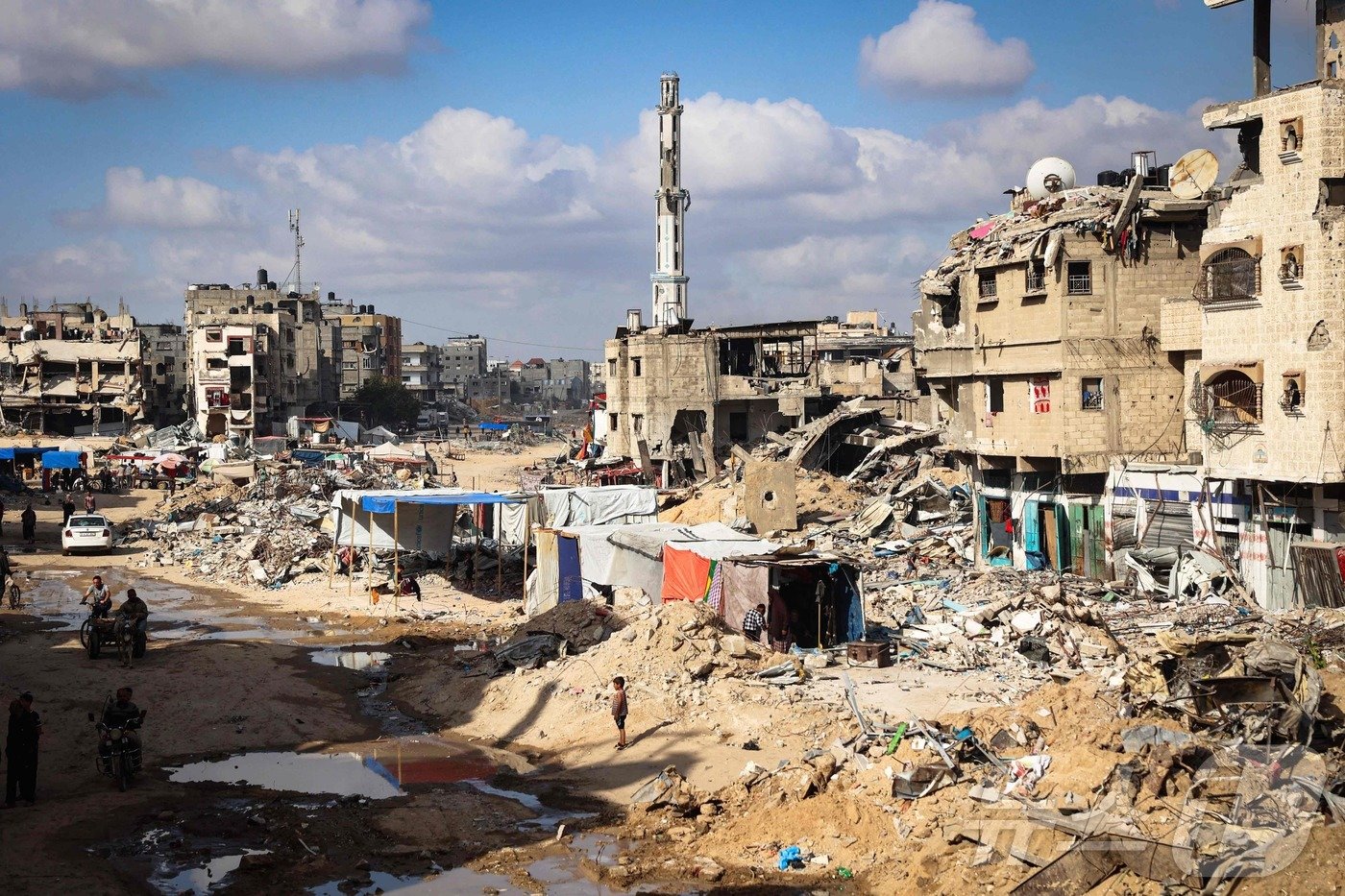 본문 이미지 - 16일&#40;현지시간&#41; 이스라엘군 공격으로 폐허가 된 가자지구 남쪽 도시 칸 유니스의 건물 잔해사이로 팔레스타인 피난민들의 널빤지 판잣집들이 들어서 있다. 2024.05.16 ⓒ AFP=뉴스1 ⓒ News1 김성식기자