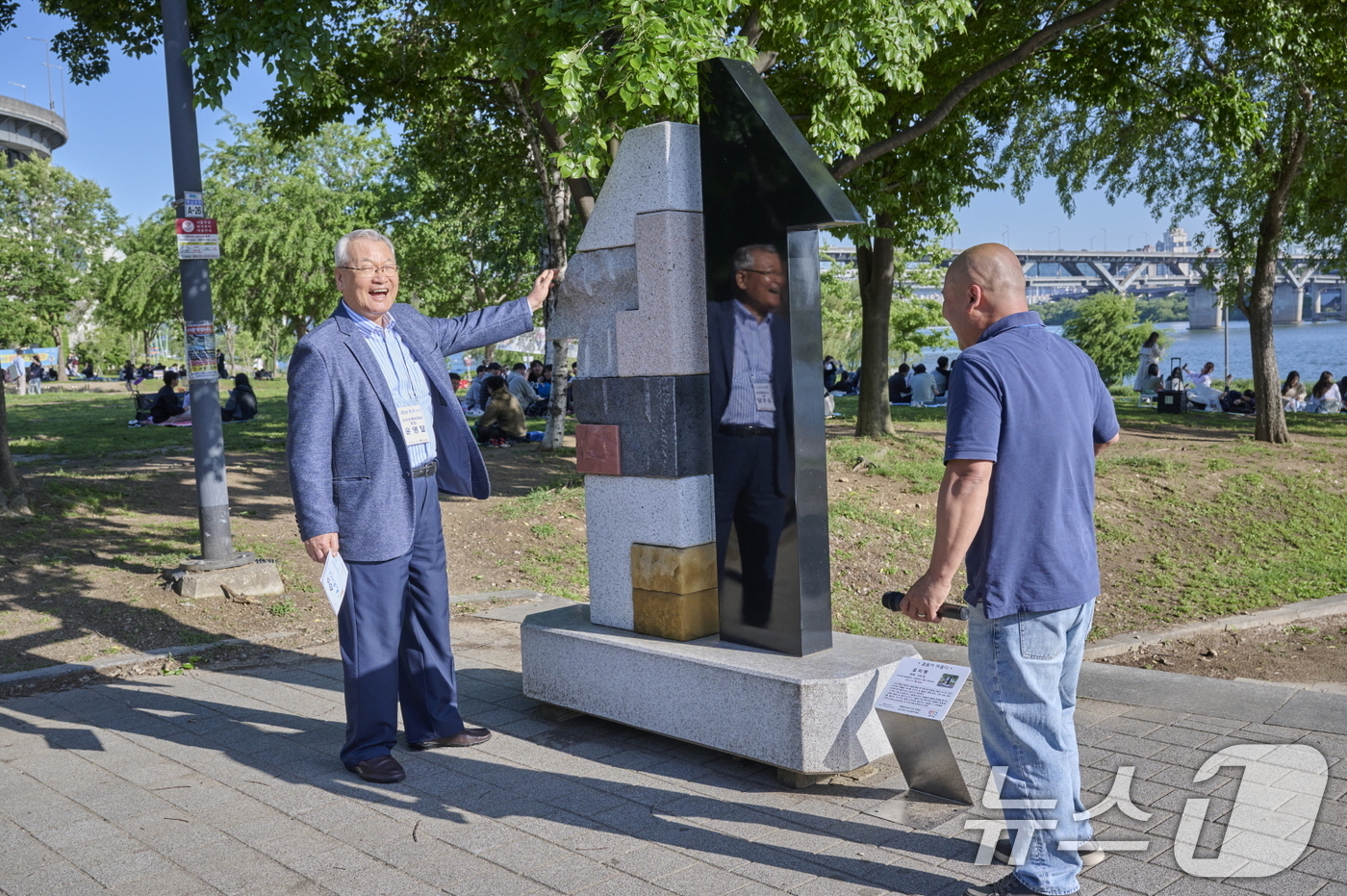 (서울=뉴스1) = 윤영달 크라운해태제과 회장이 지난 16일 서울 한강뚝섬공원에서 열린 '견생조각전 100회 기념전'에서 김지영 작가의 '관계_나의집' 작품 설명을 듣고 있다. ( …