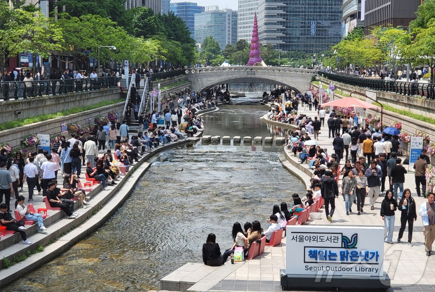 본문 이미지 - 서울 낮 최고 기온이 25도까지 오르며 초여름 날씨를 보인 17일 서울 청계천에서 열린 서울야외도서관-책 읽는 맑은 냇가에서 시민들이 의자에 앉아 책을 보며 휴식을 취하고 있다. 2024.5.17/뉴스1