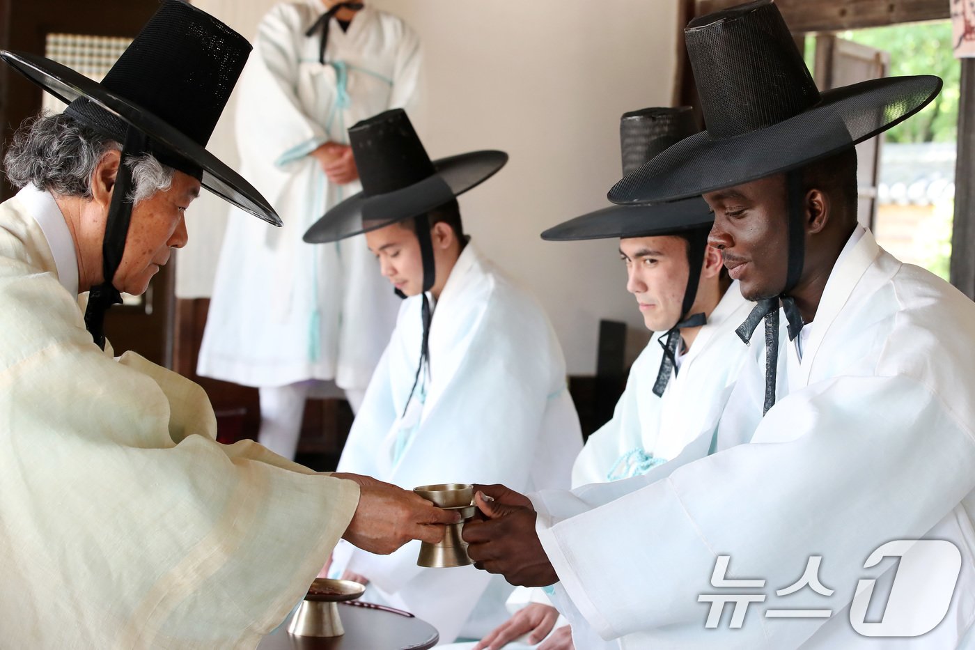 본문 이미지 - 성년의 날(20일·매년 5월 셋째 월요일)을 사흘 앞둔 17일 영남대학교 민속촌 구계서원에서 열린 '2024학년도 외국인 유학생과 함께하는 전통 성년식'에 참여한 남학생들이 술잔을 받고 있다. 2024.5.17/뉴스1 ⓒ News1 공정식 기자