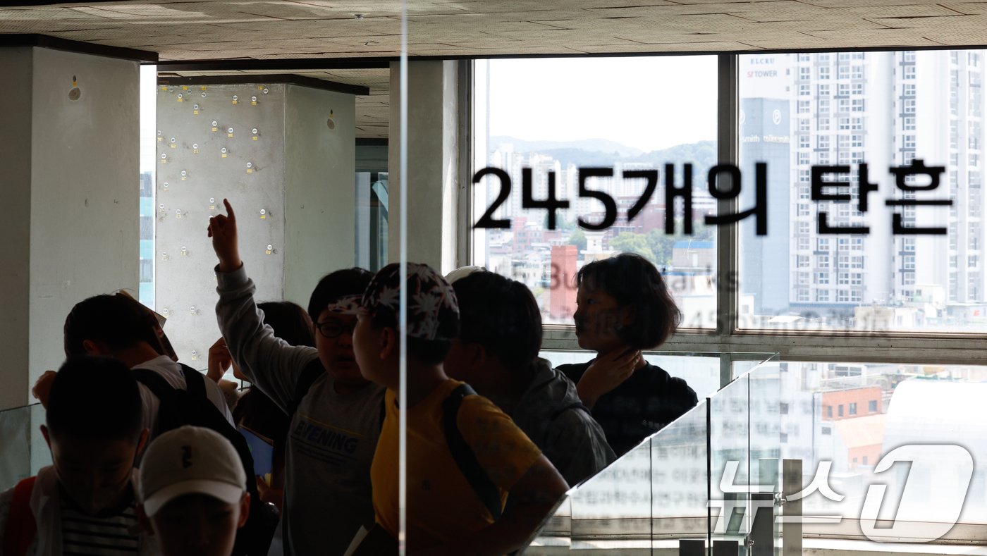 본문 이미지 - 5·18민주화운동 44주년을 하루 앞둔 지난 5월 17일 전남 광주 동구 전일빌딩245을 찾은 학생들이 1980년 당시 총탄 흔적을 살펴보고 있다. 2024.5.17/뉴스1 ⓒ News1 안은나 기자