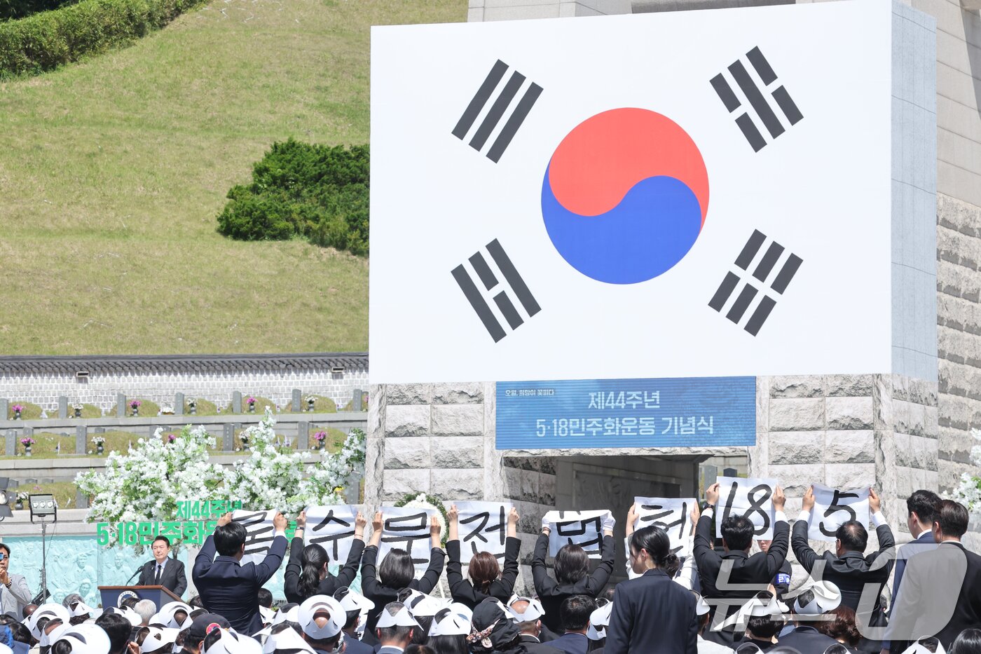 본문 이미지 - 제44주년 5.18민주화운동 기념식이 열린 18일 오전 윤석열 대통령의 기념사 도중 광주시의회 5.18특위 위원 8명이 '5.18 헌번전문수록'이 적힌 소형 현수막을 들고 기습 퍼포먼스를 벌이고 있다. 2024.5.18/뉴스1 ⓒ News1 김태성 기자