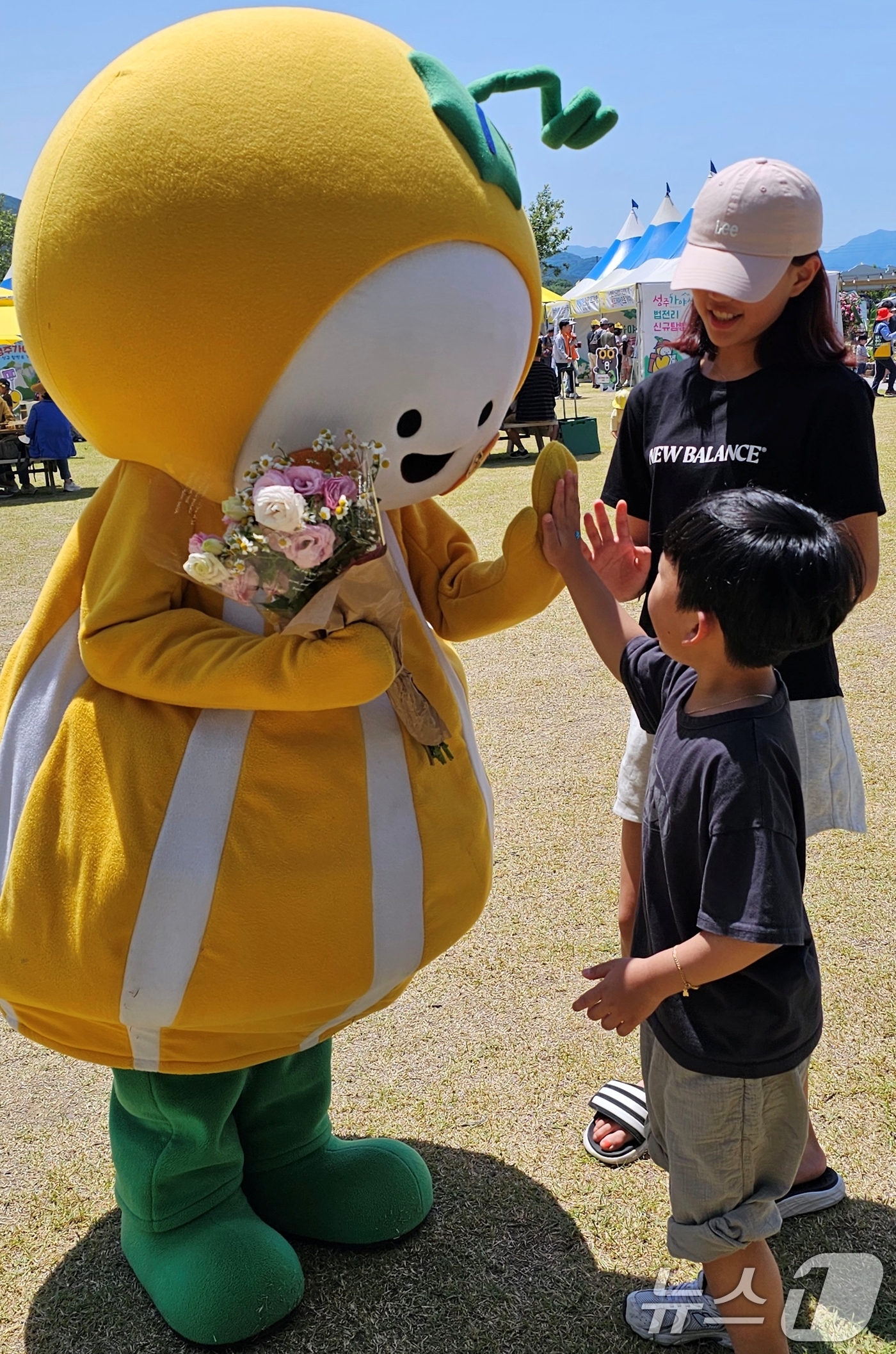 (성주=뉴스1) 정우용 기자 = 18일 성주 성밖숲에서 열린 '2024 성주생명·참외문화축제장에서 성주군 캐릭터 '참별이'가 어린이들과 기념사진을 찍고 있다.  2024.5.18/ …