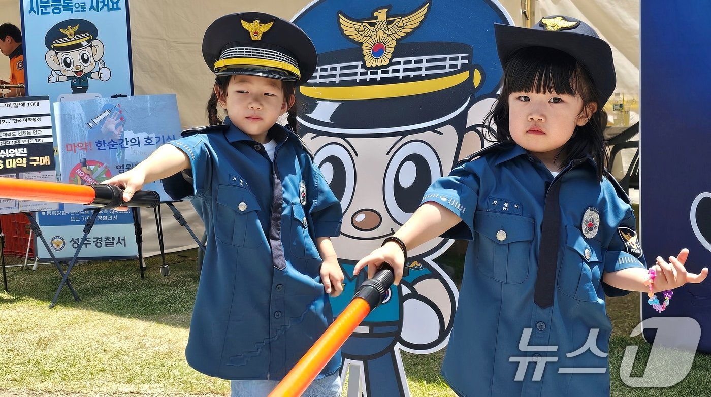 본문 이미지 - 18일 성주 성밖숲에서 열린 '2024 성주생명·참외문화축제장 경찰관 체험코너에서 어린이들이 경찰복을 입어보고 있다. 2024.5.18/뉴스1 ⓒ News1 정우용 기자