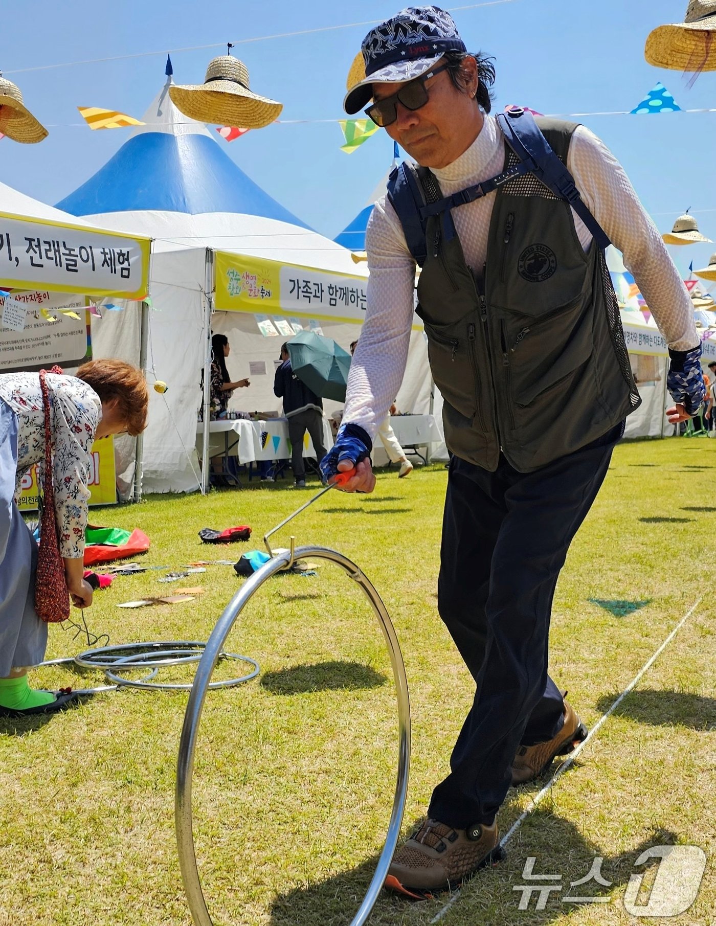 본문 이미지 - 18일 성주 성밖숲에서 열린 '2024 성주생명·참외문화축제장에서 한 시민이 굴렁쇠를 굴리고 있다. 2024.5.18/뉴스1 ⓒ News1 정우용 기자
