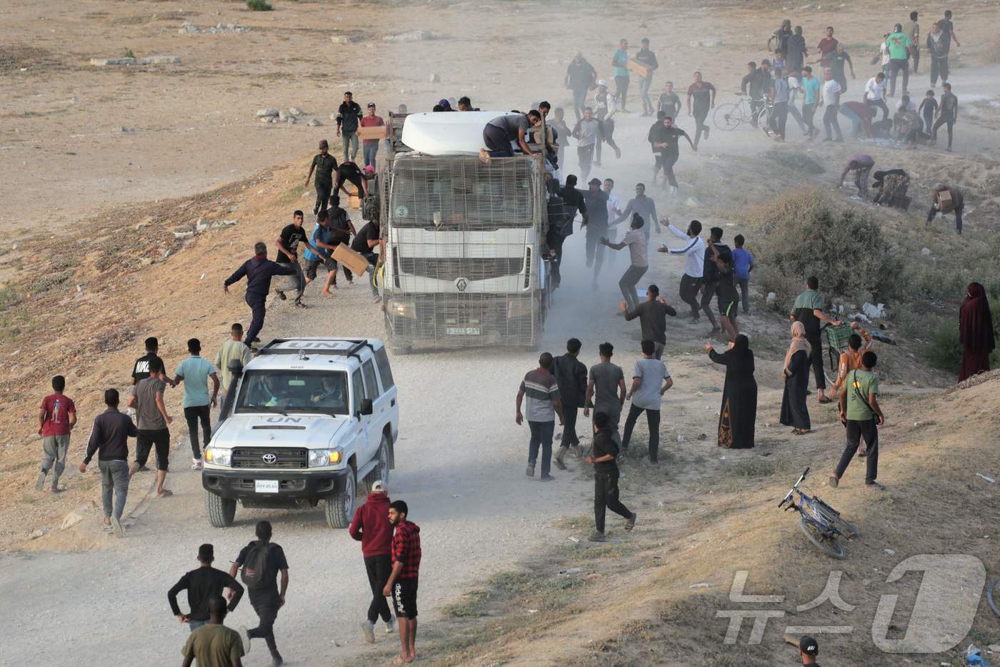 18일&#40;현지시간&#41; 팔레스타인 가자 지구 누세이라트 인근에서 주민들이 국제 인도주의 지원 트럭을 향해 몰려 들고 있다. 2024.05.19 ⓒ AFP=뉴스1 ⓒ News1 우동명 기자
