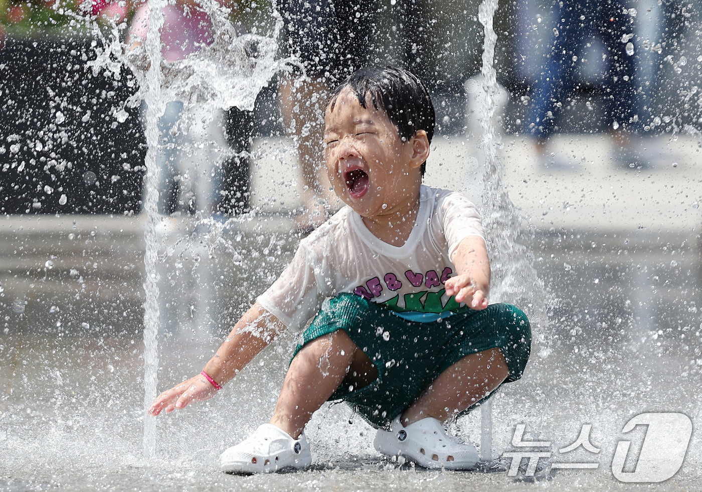(서울=뉴스1) 김민지 기자 = 서울 낮 최고 기온이 28도에 오르는 등 초여름 더위를 보인 19일 오후 서울 종로구 광화문광장에서 한 아이가 물놀이를 하며 즐거운 시간을 보내고 …