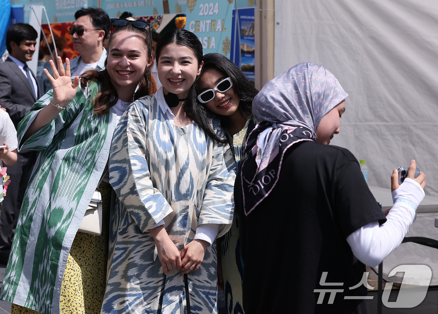 (서울=뉴스1) 김진환 기자 = 19일 청계광장에서 열린 '2024 중앙아시아 봄맞이 축제'에서 한 외국인 관광객들이 우즈베키스탄 부스에서 전통 의상을 입고 카메라를 보며 환한 미 …