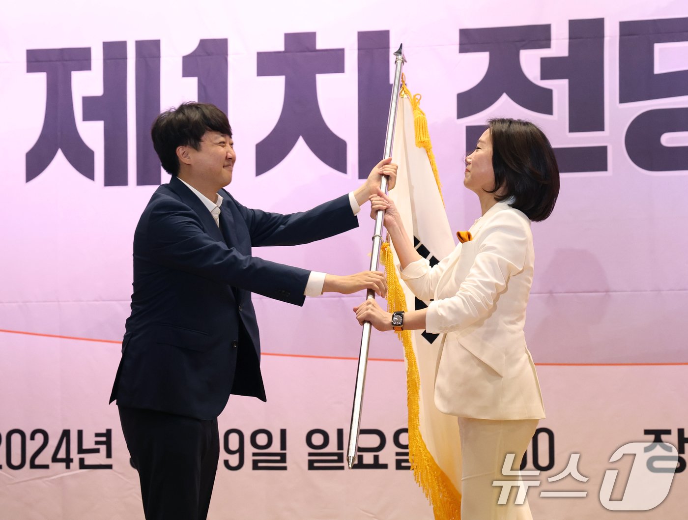 본문 이미지 - 이준석 개혁신당 대표가 19일 서울 여의도 국회 의원회관에서 열린 개혁신당 전당대회에서 허은아 신임 당대표에게 당기를 전달하고 있다. 2024.5.19/뉴스1 ⓒ News1 송원영 기자