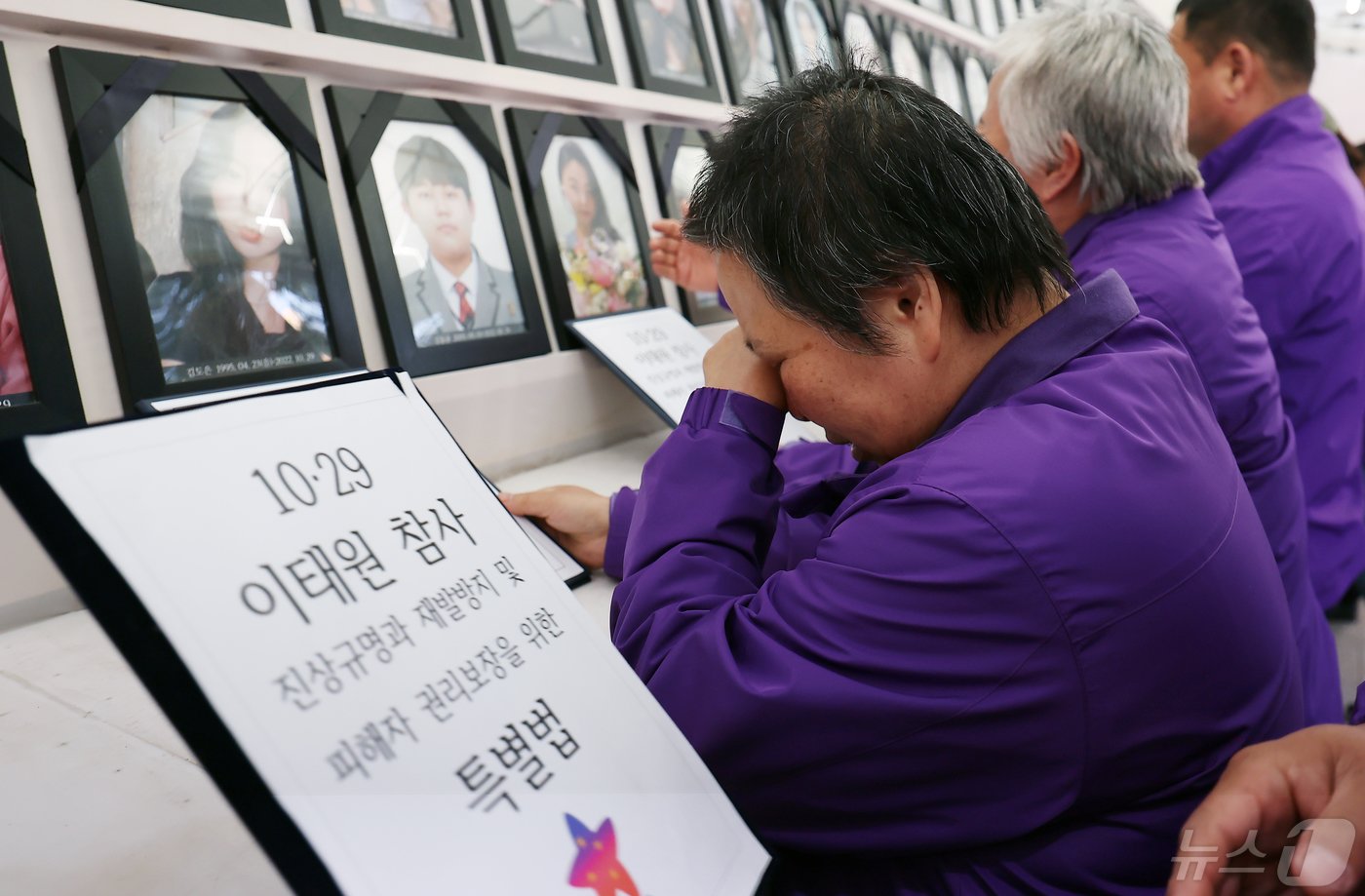 이태원참사특별법이 국회 본회의를 통과한 2일 오후 서울 중구 서울광장 분향소 앞에서 열린 10.29 이태원 참사 특별법 여야합의 국회통과 추모문화제에서 유가족들이 이태원참사특별법안이 담긴 서류를 영정사진 앞에 놓으며 눈물을 흘리고 있다. 2024.5.2/뉴스1 ⓒ News1 김민지 기자