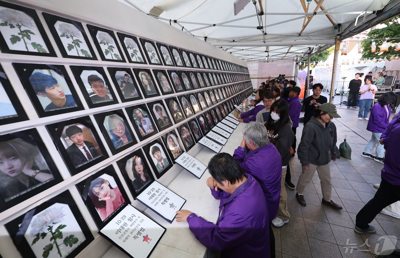 이태원참사특별법이 국회 본회의를 통과한 2일 오후 서울 중구 서울광장 분향소 앞에서 열린 10.29 이태원 참사 특별법 여야합의 국회통과 추모문화제에서 유가족들이 이태원참사특별법안이 담긴 서류를 영정사진 앞에 놓으며 눈물을 흘리고 있다. 2024.5.2/뉴스1 ⓒ News1 김민지 기자