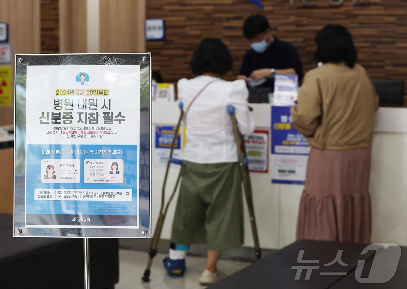 건강보험 본인확인 의무화 제도가 시행된 20일 오전 서울 동작구 한 병원에서 시민들이 접수를 하며 신분증을 보여주고 있다. 2024.5.20/뉴스1 ⓒ News1 김민지 기자