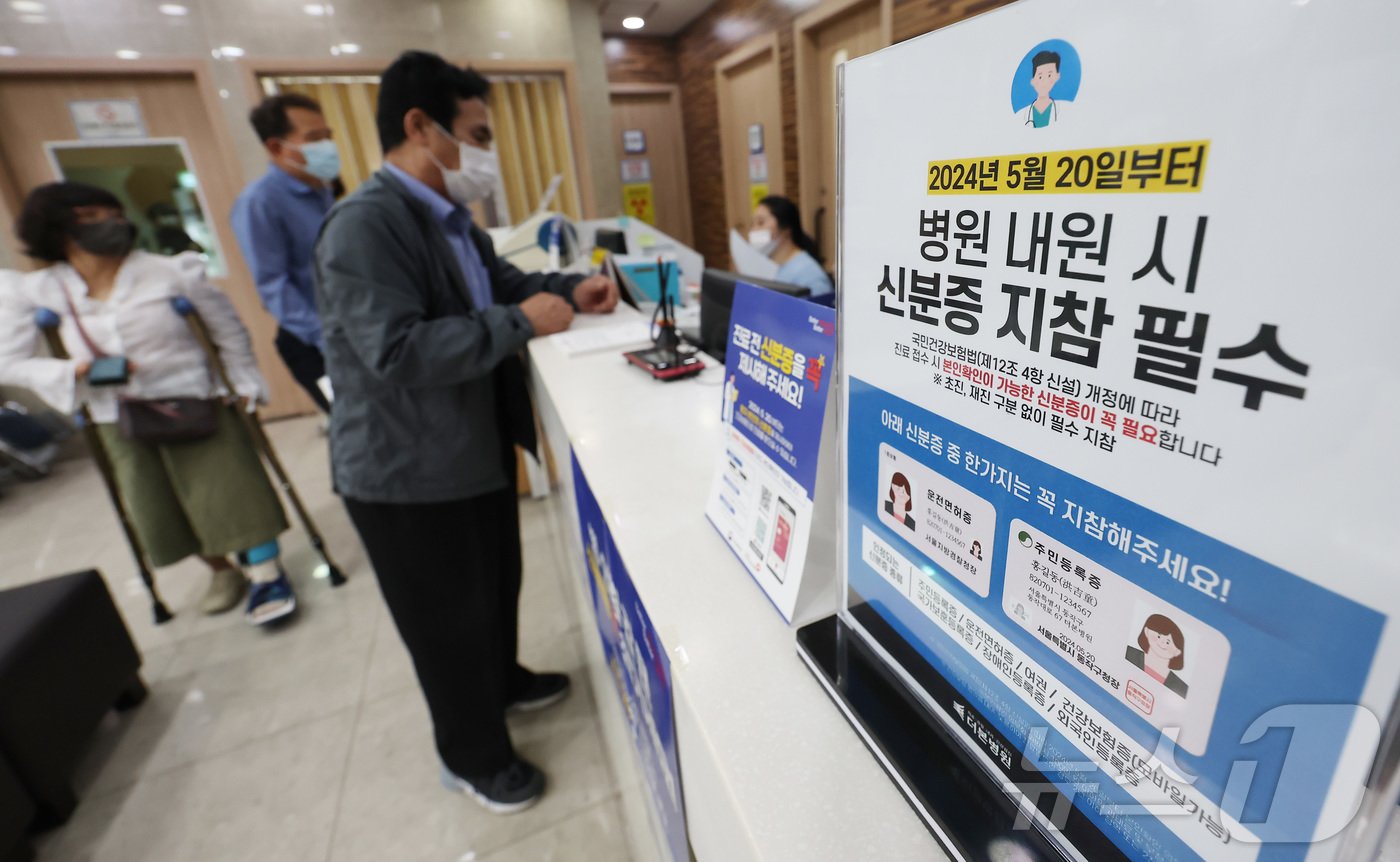 본문 이미지 - 건강보험 본인확인 의무화 제도가 시행된 20일 오전 서울 동작구 한 병원에 신분증 지참 안내문이 놓여 있다.  2024.5.20/뉴스1 ⓒ News1 김민지 기자