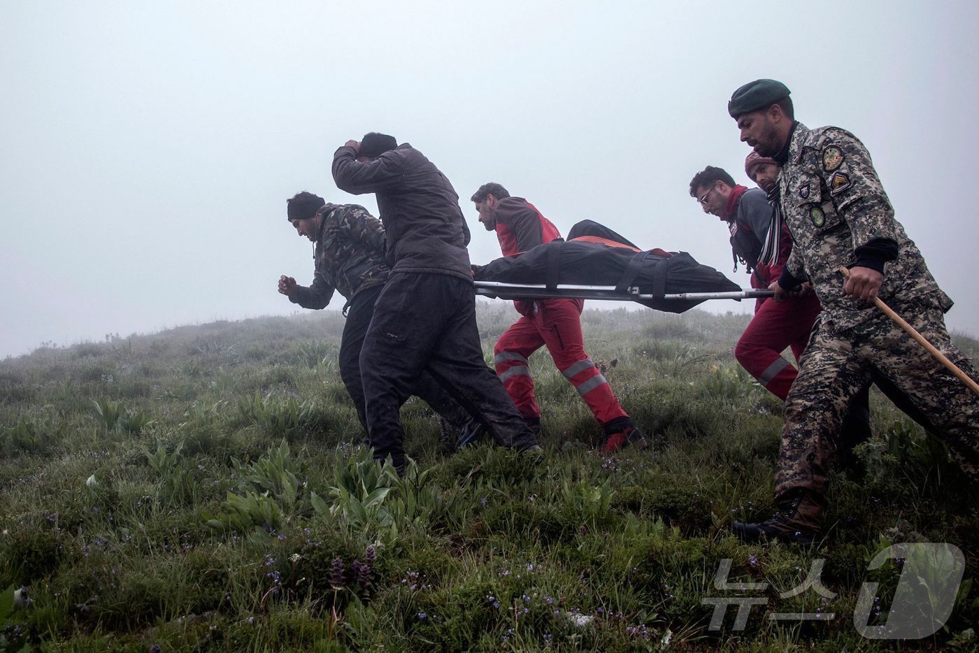 본문 이미지 - 20일(현지시간) 에브라힘 라이시 이란 대통령을 태운 헬기가 추락한 바르자간 산악 지역에서 구조대원들이 시신을 옮기고 있다. 2024.05.21 ⓒ AFP=뉴스1 ⓒ News1 우동명 기자