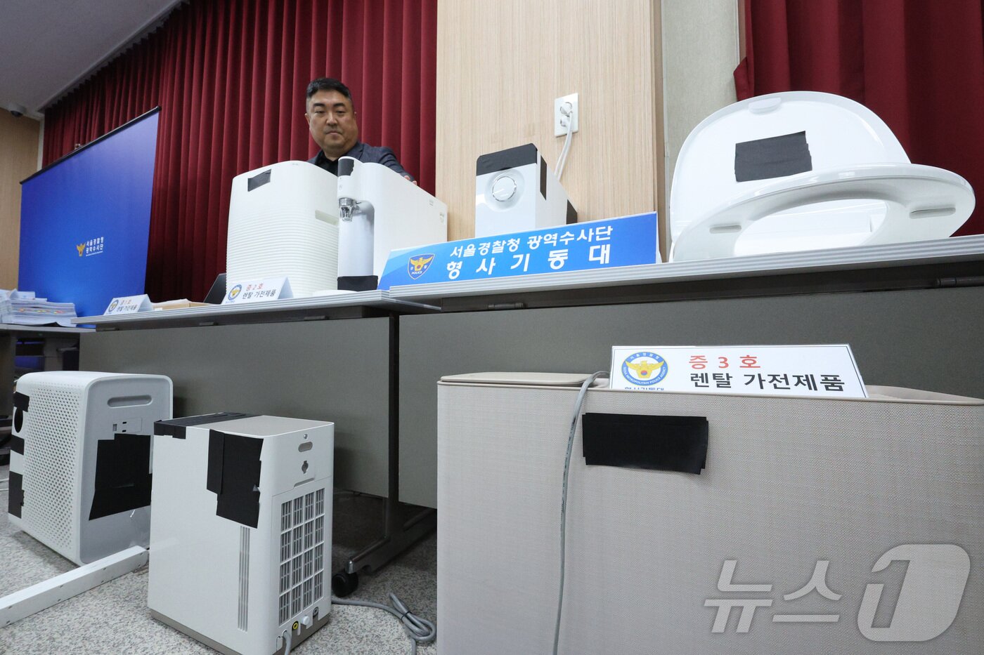 본문 이미지 - 21일 서울 마포구 서울경찰청 광역수사대에서 경찰이 일명 '내구제 대출' 방식으로 약 26억원을 편취한 일당으로부터 압수한 물품을 살펴보고 있다. 서울경찰청 광역수사단 형사기동대는 지난 2017년부터 2022년까지 내구제 대출 희망자 명의로 유령법인을 만들어 약 26억원을 편취한 일당 44명을 사기 혐의로 검거하고 총책 A 씨 등 5명을 구속했다고 밝혔다. 내구제 대출은 '내가 나를 구제하는 대출'이라는 뜻의 불법사금융으로 휴대전화·가전제품 등을 빌리고 불법 대출업자에게 넘긴 뒤 대가로 현금을 받는 방식으로 이뤄진다. 2024.5.21/뉴스1 ⓒ News1 신웅수 기자