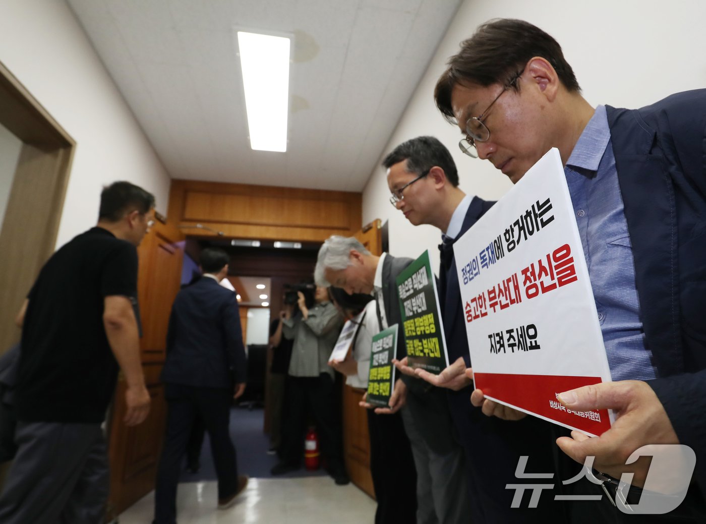 21일 오후 부산 금정구 부산대학교 대학본부에서 의과대학 정원 증원 학칙개정안 재심의를 위한 교무회의가 열린 가운데 의대생들과 교수들이 피켓 시위를 벌이고 있다. 2024.5.21/뉴스1 ⓒ News1 윤일지 기자