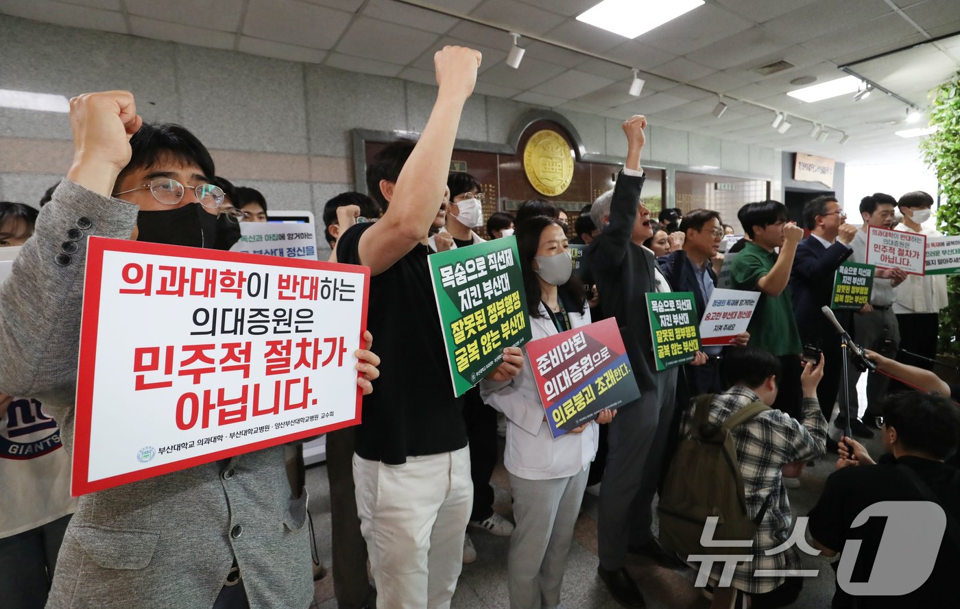 21일 오후 부산 금정구 부산대학교 대학본부에서 의과대학 정원 증원 학칙개정안 재심의를 위한 교무회의가 열린 가운데 의대생들과 교수들이 피켓을 들고 기자회견을 하고 있다. 2024.5.21/뉴스1 ⓒ News1 윤일지 기자