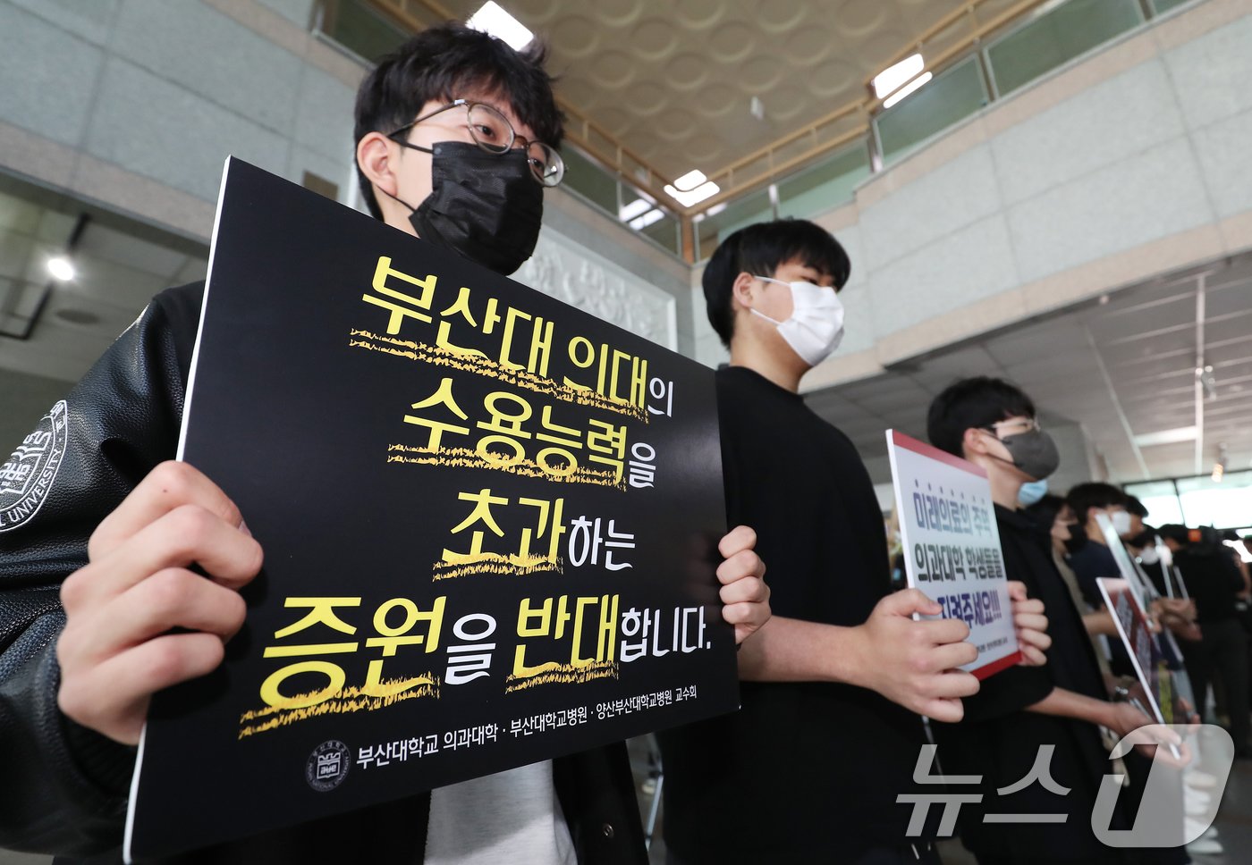 본문 이미지 - 21일 오후 부산 금정구 부산대학교 대학본부에서 의과대학 정원 증원 학칙개정안 재심의를 위한 교무회의가 열린 가운데 의대생들과 교수들이 피켓 시위를 벌이고 있다.  2024.5.21/뉴스1 ⓒ News1 윤일지 기자