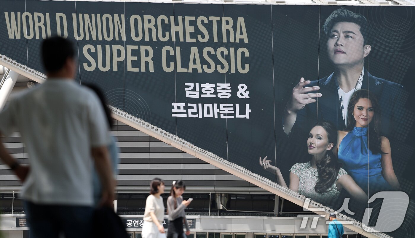 본문 이미지 - 22일 오후 서울 송파구 올림픽공원 KSPO돔(체조경기장)에 설치된 '월드 유니온 오케스트라 슈퍼 클래식 : 김호중 & 프리마돈나’ 현수막 앞으로 시민들이 지나가고 있다.2024.5.22/뉴스1 ⓒ News1 박지혜 기자