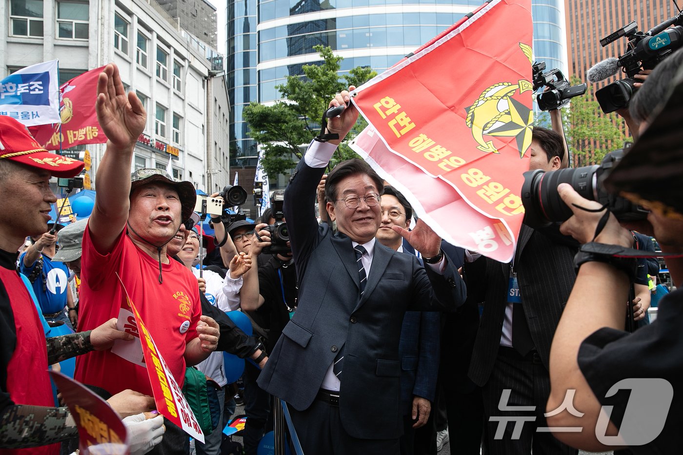 이재명 더불어민주당 대표가 25일 오후 서울 중구 숭례문 인근에서 열린 범야당 및 시민사회 &#39;채상병 특검법 거부 규탄 및 통과 촉구 범국민대회&#39;에 참석하며 해병대 예비역들과 인사하며 해병대 깃발을 들어보이고 있다. 2024.5.25/뉴스1 ⓒ News1 이승배 기자