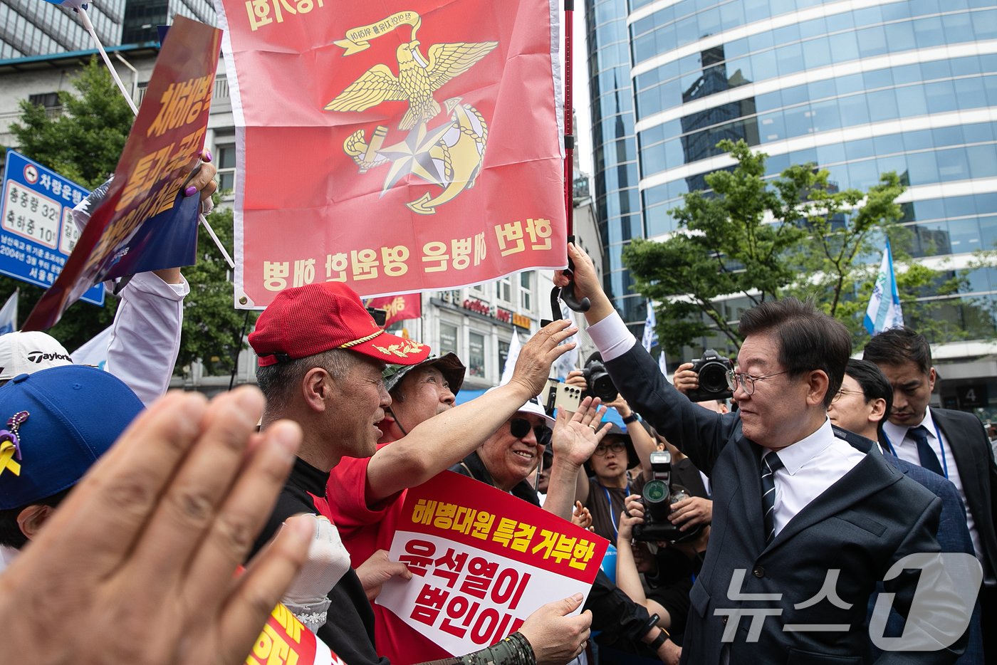 이재명 더불어민주당 대표가 25일 오후 서울 중구 숭례문 인근에서 열린 범야당 및 시민사회 &#39;채상병 특검법 거부 규탄 및 통과 촉구 범국민대회&#39;에 참석하며 해병대 예비역들과 인사하며 해병대 깃발을 들어보이고 있다. 2024.5.25/뉴스1 ⓒ News1 이승배 기자