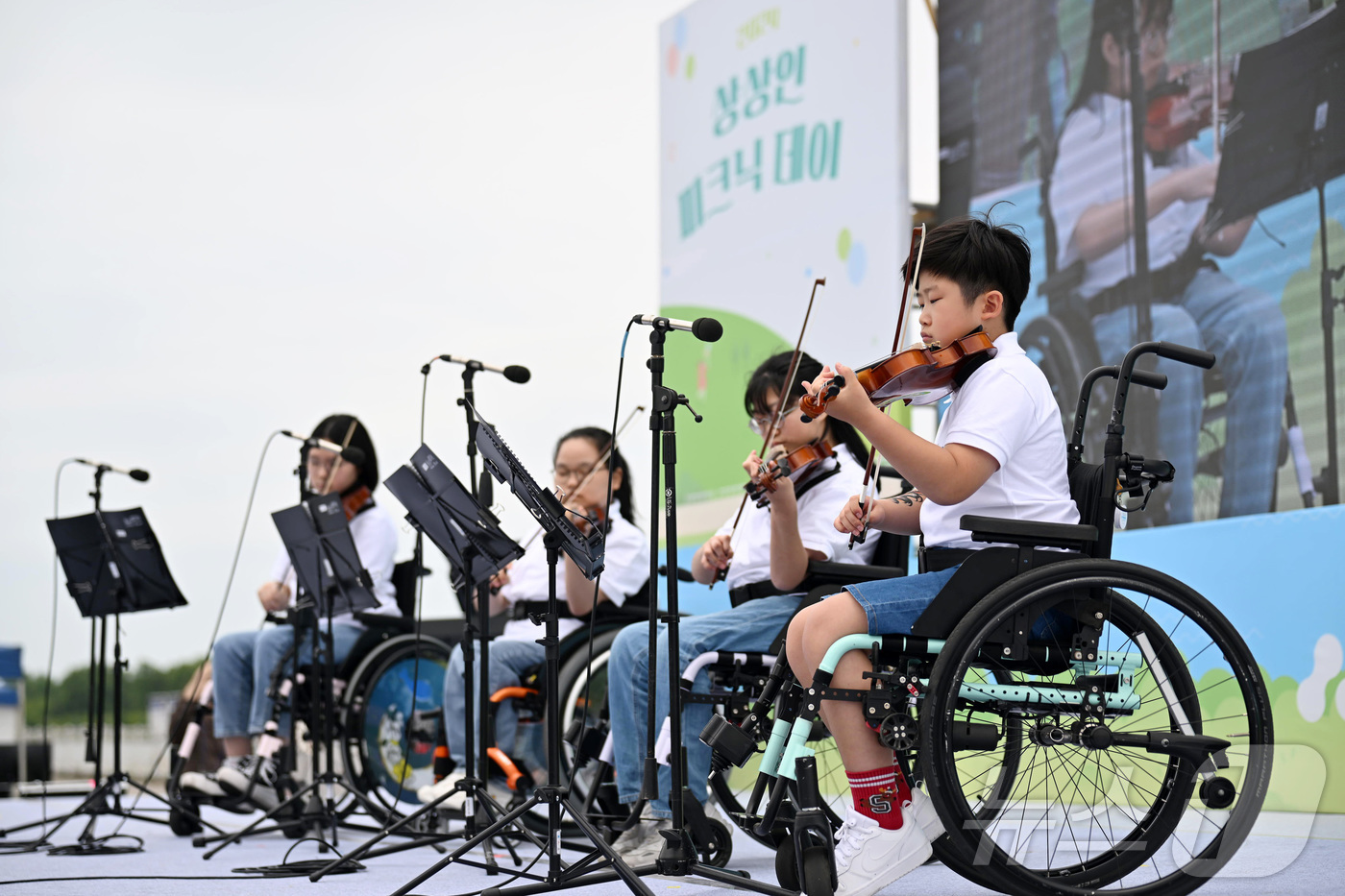(서울=뉴스1) = 지난 25일 경기도 하남 미사경정공원에서 열린 ‘2024 상상인 피크닉데이’에서 휠체어 사용 아동들이 ‘아카데미 상상인’을 통해 배운 바이올린을 연주하고 있다. …