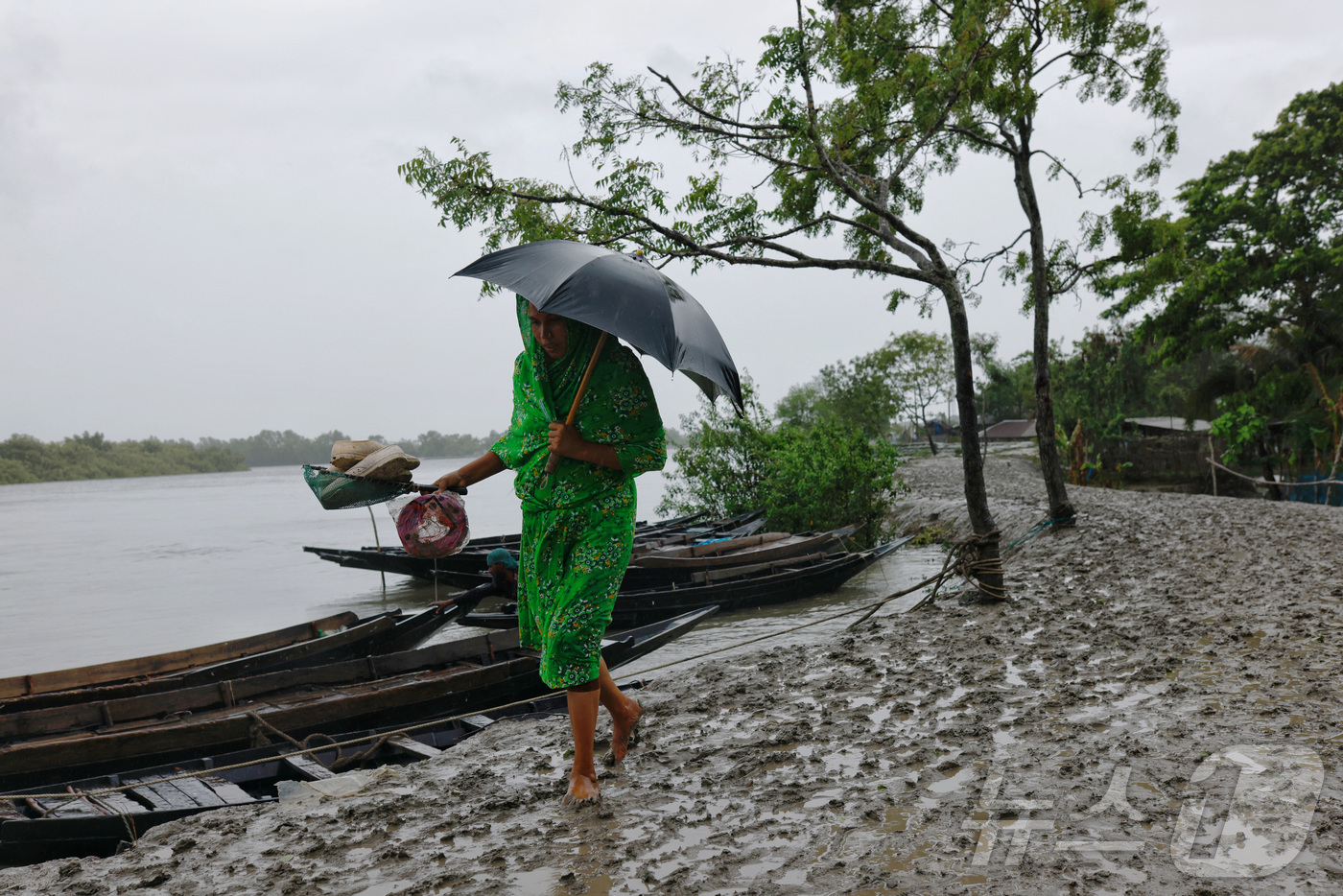 (사트키라 로이터=뉴스1) 정지윤 기자 = 26일(현지시간) 한 여성이 방글라데시 사트키라 샤암나가르 지역에서 사이클론이 강타하기 전 진흙길을 걷고 있다. 2024.05.26ⓒ 로 …