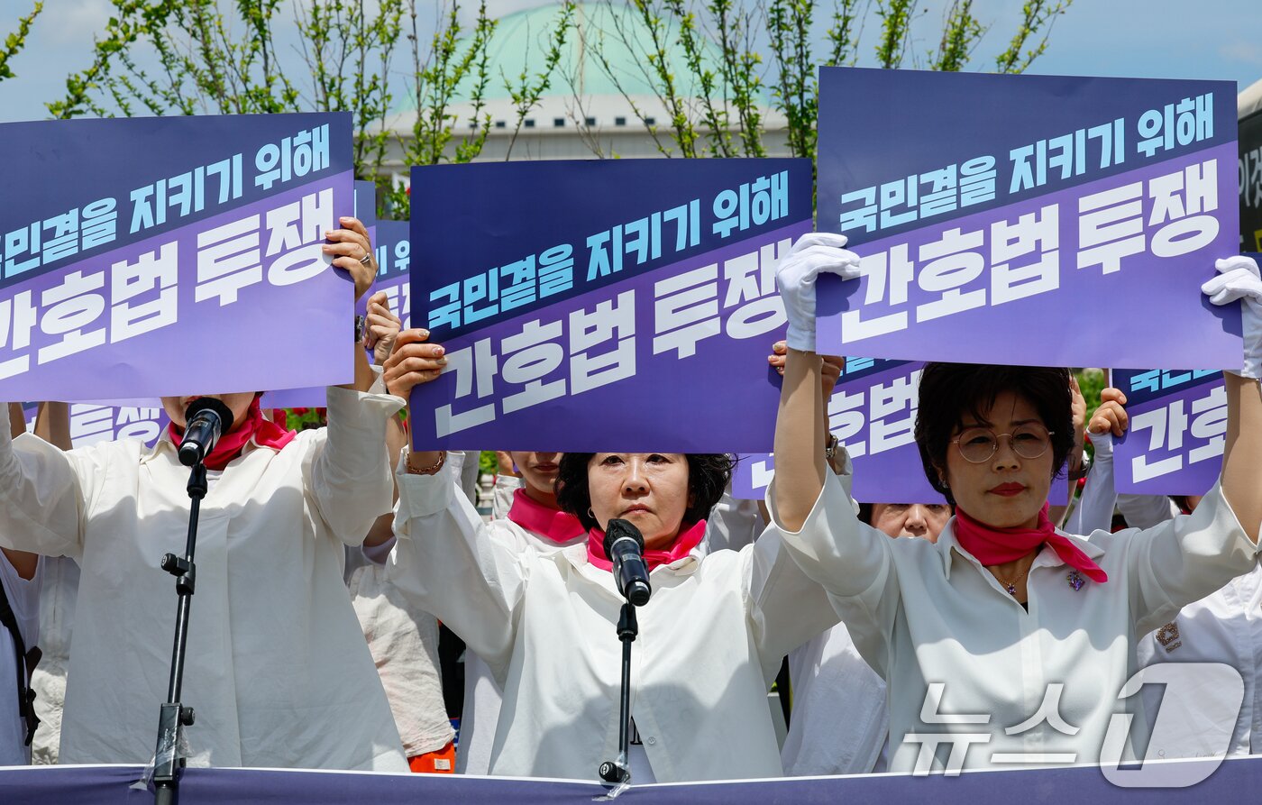 본문 이미지 - 대한간호협회 소속 간호사들이 27일 서울 여의도 국회의사당 앞에서 &#39;간호법안 제정 촉구 집회&#39;를 연 뒤 21대 국회를 향해 간호법 통과를 촉구하며 구호를 외치고 있다. 2024.5.27/뉴스1 ⓒ News1 안은나 기자