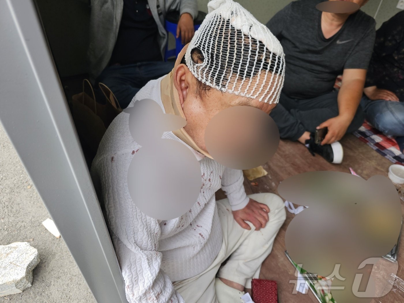 본문 이미지 - 집단 몸싸움으로 머리에 열상을 입은 70대 유치권자가 병원에서 20여 바늘을 꿰매고 다시 현장으로 나와 시위를 하고있다. 2024.5.27/뉴스1 신성훈 기자
