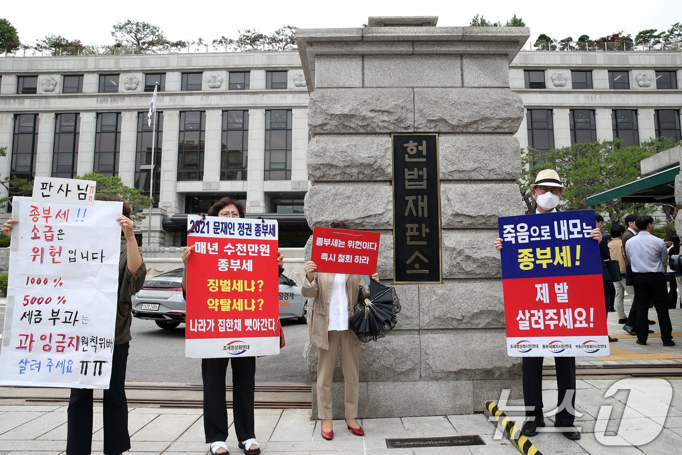 조세정의시민연대 등 종부세 폐지를 촉구하는 시민들이 30일 서울 종로구 헌법재판소 대심판정에서 열린 5월 심판사건 선고를 앞두고 피켓시위를 하고 있다. 헌재는 이날 ‘수신료 분리징수’ 헌법소원 선고, &#39;헌정사 첫 검사 탄핵심판&#39; 선고를 비롯해 대체복무제와 종부세 위헌 여부 등에 대해 결론낸다. 2024.5.30/뉴스1 ⓒ News1 오대일 기자