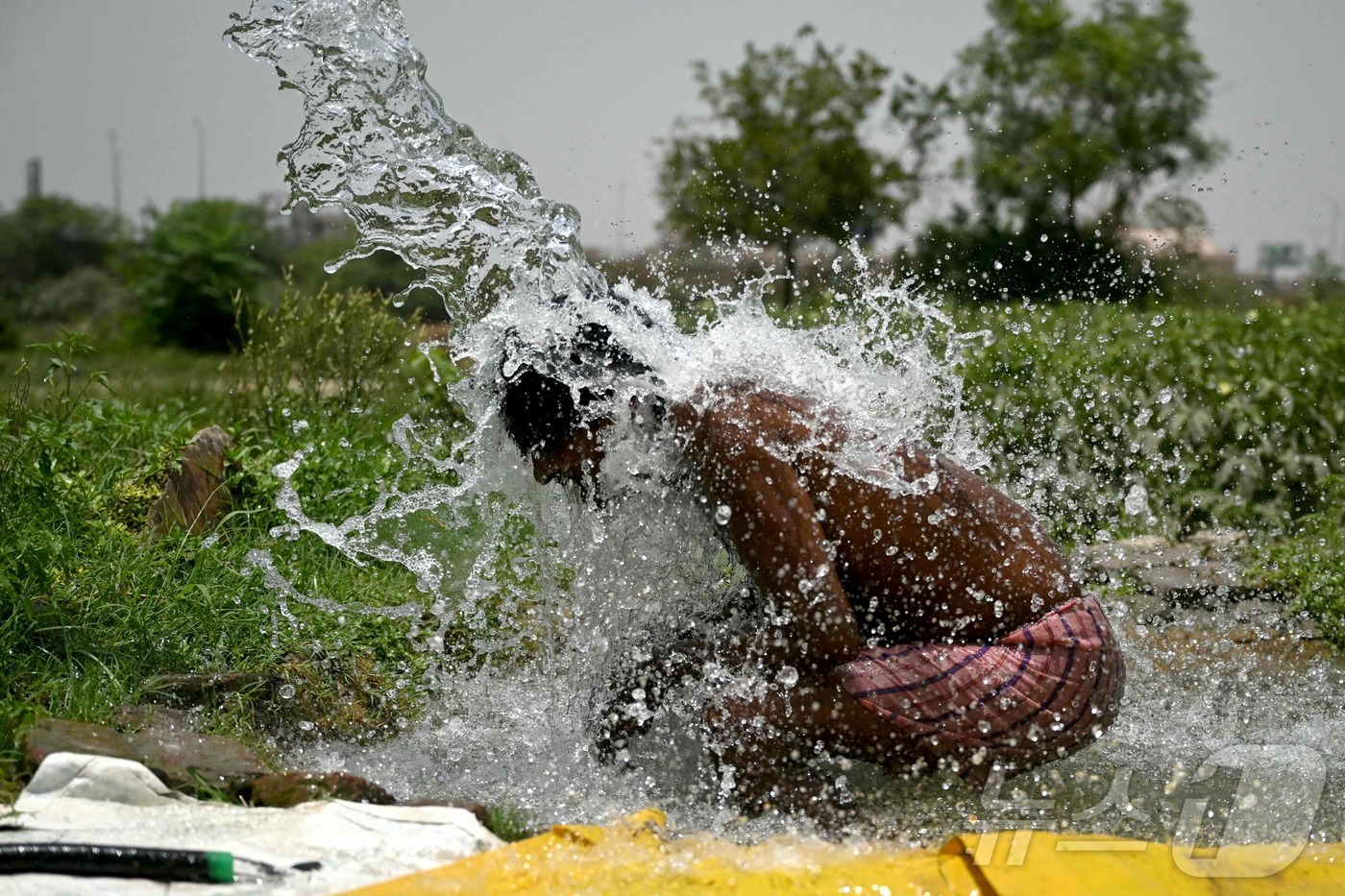 (뉴델리 AFP=뉴스1) 정지윤 기자 = 폭염이 기승을 부리는 29일(현지시간) 인도 뉴델리에서 한 남성이 몸에 물을 적시고 있다. 2024.05.29ⓒ AFP=뉴스1