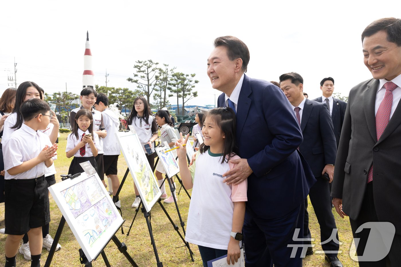 윤석열 대통령이 30일 경남 사천시 항공우주박물관 일원에서 열린 미래세대와 함께하는 우주항공 축제에서 미술부문 수상작을 관람 도중 학생과 함께 기념촬영을 하고 있다. &#40;대통령실 제공&#41; 2024.5.30/뉴스1 ⓒ News1 송원영 기자