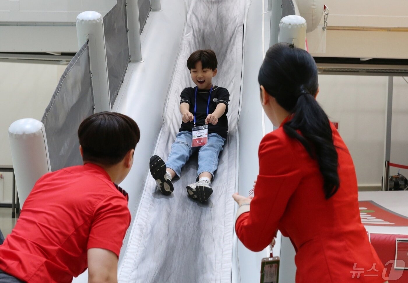 본문 이미지 - 4일 티웨이항공 훈련센터에서 가정의 달 맞이 't'family day'에 참여한 티웨이항공 임직원 가족들이 B737 항공기 슬라이드 훈련을 체험하고 있다.(티웨이항공 제공)