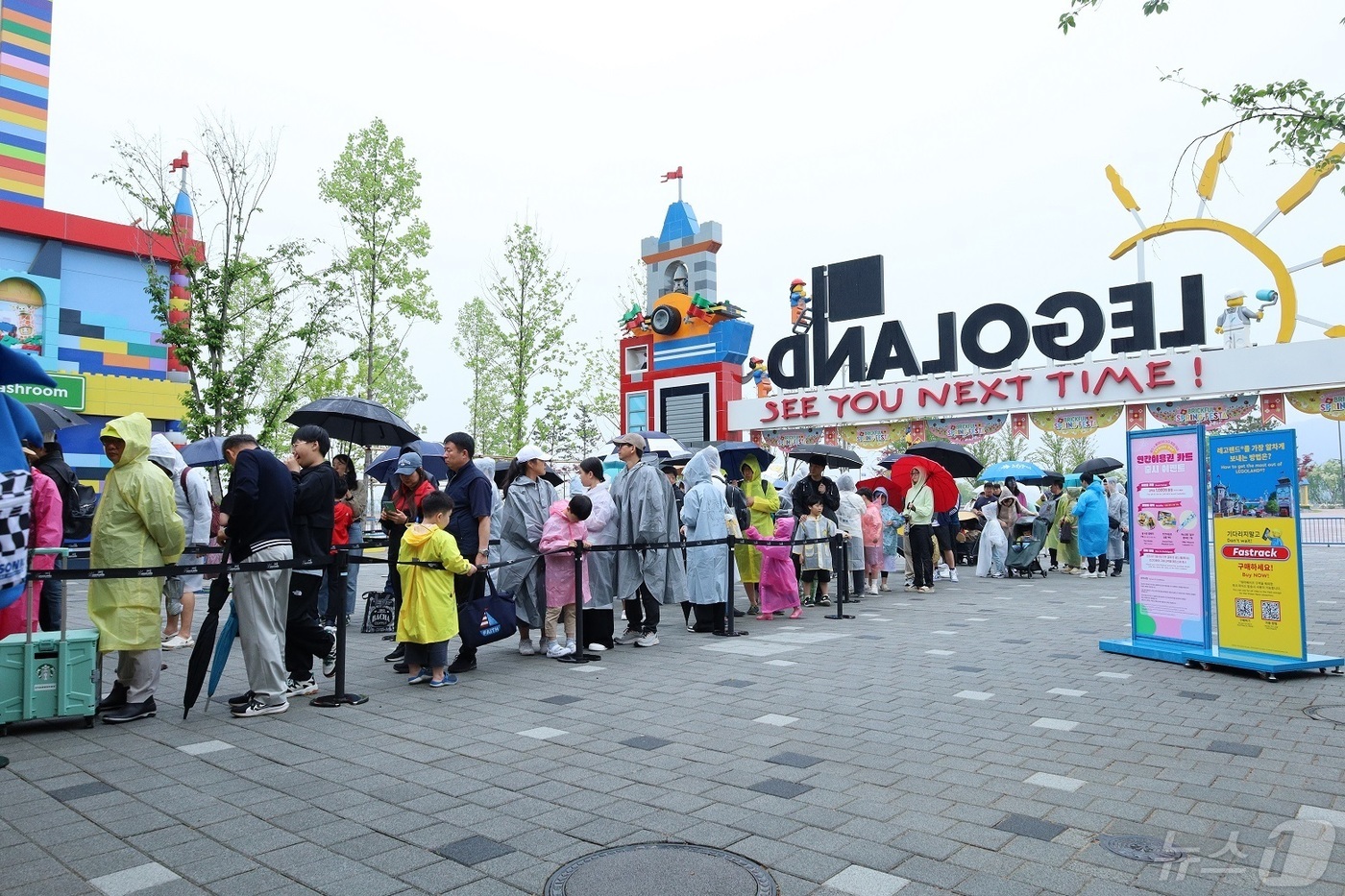 (춘천=뉴스1) 한귀섭 기자 = 어린이날인 5일 오전 강원 춘천 레고랜드 정문 앞에 우산과 우비를 쓴 어린이들이 부모와 함께 입장을 하기 위해 기다리고 있다.(레고랜드 제공) 20 …