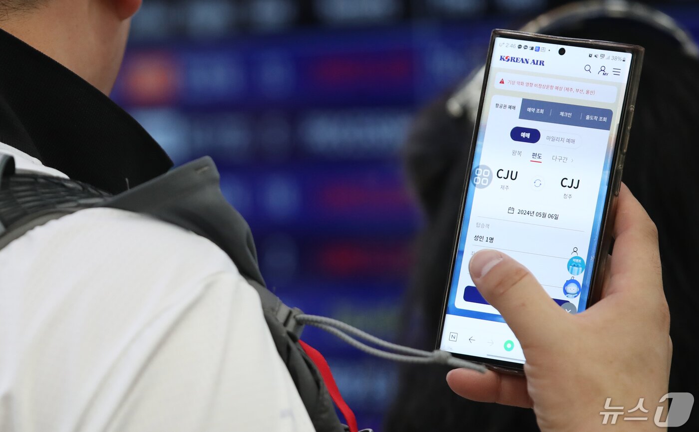 본문 이미지 - 공항 출발장에서 한 승객이 휴대전화로 항공권을 검색하고 있는 모습. /뉴스1DB ⓒ News1 오현지 기자