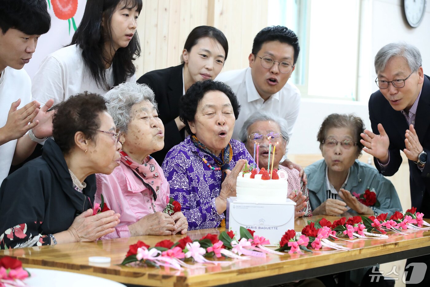 본문 이미지 - 어버이날을 하루 앞둔 7일 오전 대구 달서구 경증치매노인종합지원시설 대구샘기억학교에서 학교 관계자들이 어르신에게 카네이션을 달아준 뒤 함께 축하 케이크 촛불을 끄고 있다. 2024.5.7/뉴스1 ⓒ News1 공정식 기자