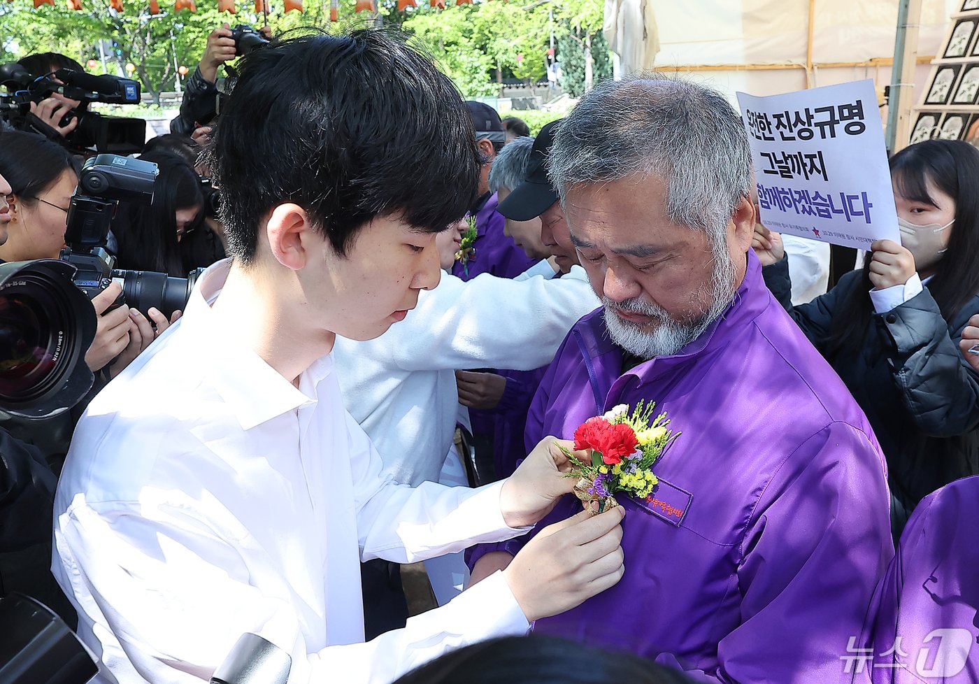 본문 이미지 - 이정민 10.29 이태원 참사 유가족협의회 운영위원장을 비롯한 유가족들이 8일 오전 서울 중구 서울광장 분향소 앞에서 열린 '10.29 이태원참사 온전한 진상규명을 위해 거리에서 맞는 두 번째 어버이날 행사'에서 학생들에게 카네이션을 받고 있다. 2024.5.8/뉴스1 ⓒ News1 김진환 기자