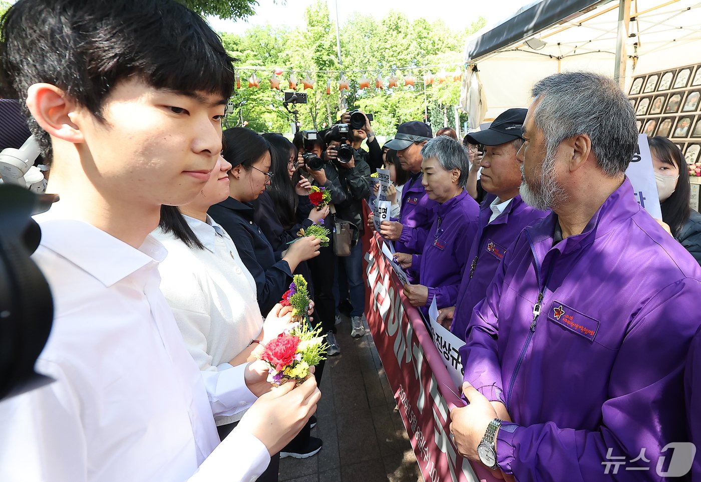 본문 이미지 - 10.29 이태원 참사 유가족들이 8일 오전 서울 중구 서울광장 분향소 앞에서 열린 '10.29 이태원참사 온전한 진상규명을 위해 거리에서 맞는 두 번째 어버이날 행사'에서 학생들에게 카네이션을 받고 있다. 2024.5.8/뉴스1 ⓒ News1 김진환 기자