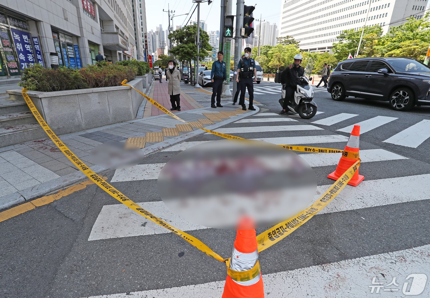 본문 이미지 - 9일 오전 부산 연제구 부산지방법원 앞에서 유튜브 채널을 운영하는 50대 남성이 또 다른 유튜버인 50대 남성에게 흉기를 휘두른 사건이 발생한 가운데 경찰관들이 사건 현장을 정리하고 있다. 피해자는 심정지 상태에서 병원으로 이송됐으나 사망했다. 경찰은 도주한 용의자를 경북 경주에서 검거했다. 2024.5.9/뉴스1 ⓒ News1 윤일지 기자