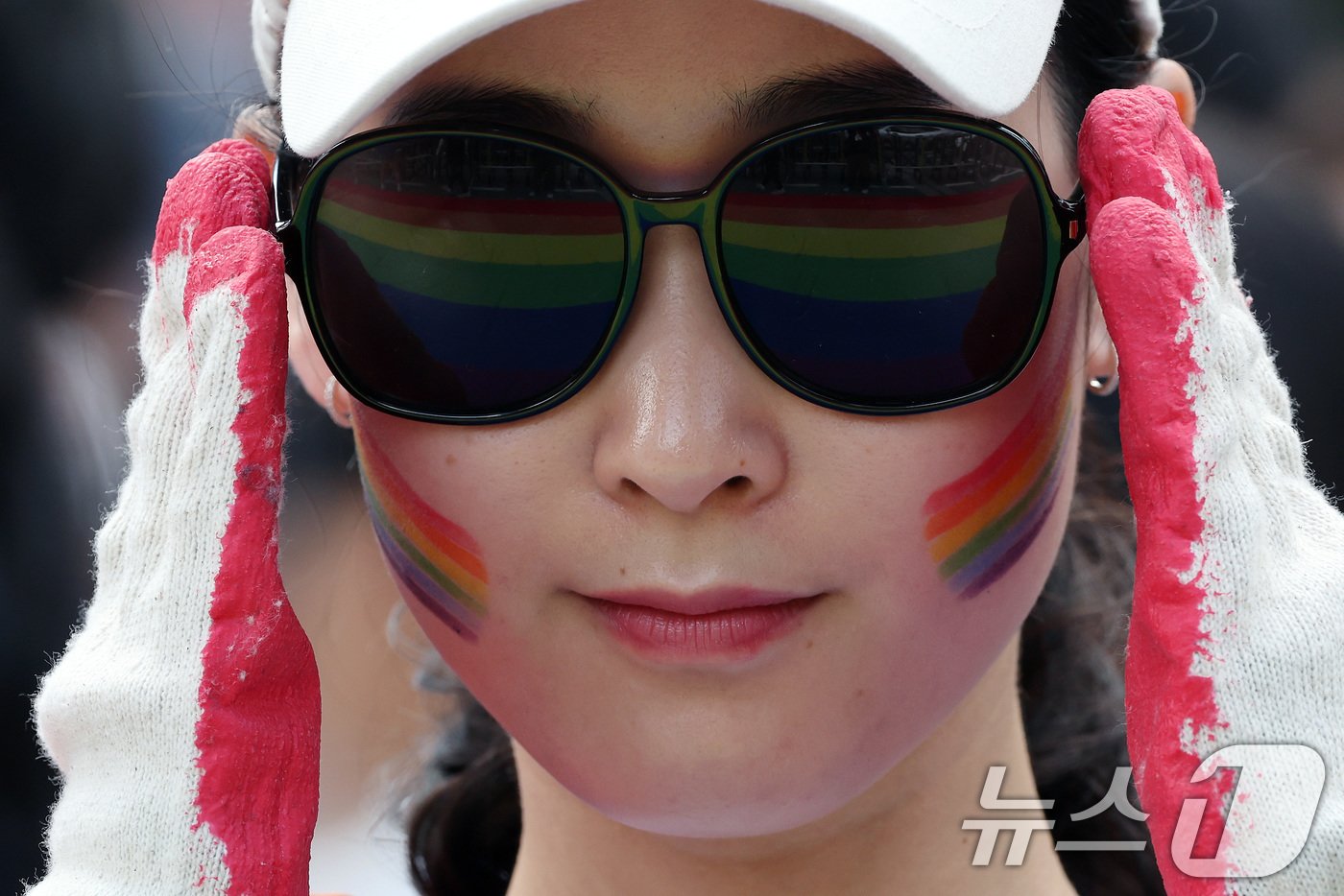 본문 이미지 - 1일 오후 서울 종각역 일대에서 열린 '2024 서울퀴어문화축제'를 찾은 한 시민의 선글라스에 무지개 깃발이 비치고 있다. 2024.6.1/뉴스1 ⓒ News1 이동해 기자