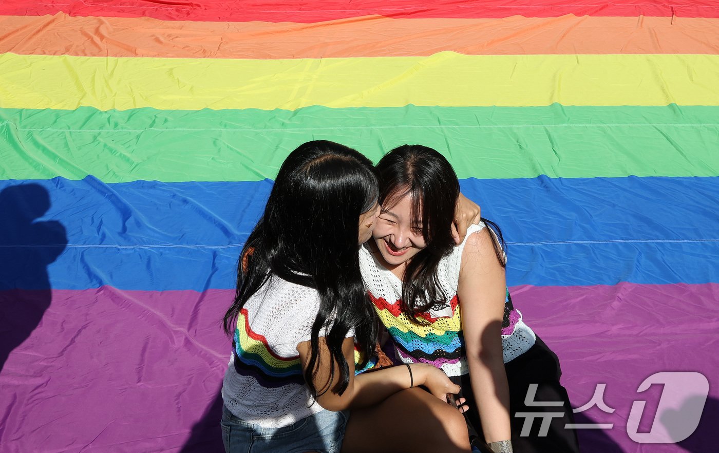 1일 오후 서울 종각역 일대에서 열린 &#39;2024 서울퀴어문화축제&#39;를 찾은 정유진&#40;29&#41;, 이하림&#40;34&#41; 커플이 무지개 깃발 위에 앉아 포즈를 취하고 있다. 2024.6.1/뉴스1 ⓒ News1 이동해 기자