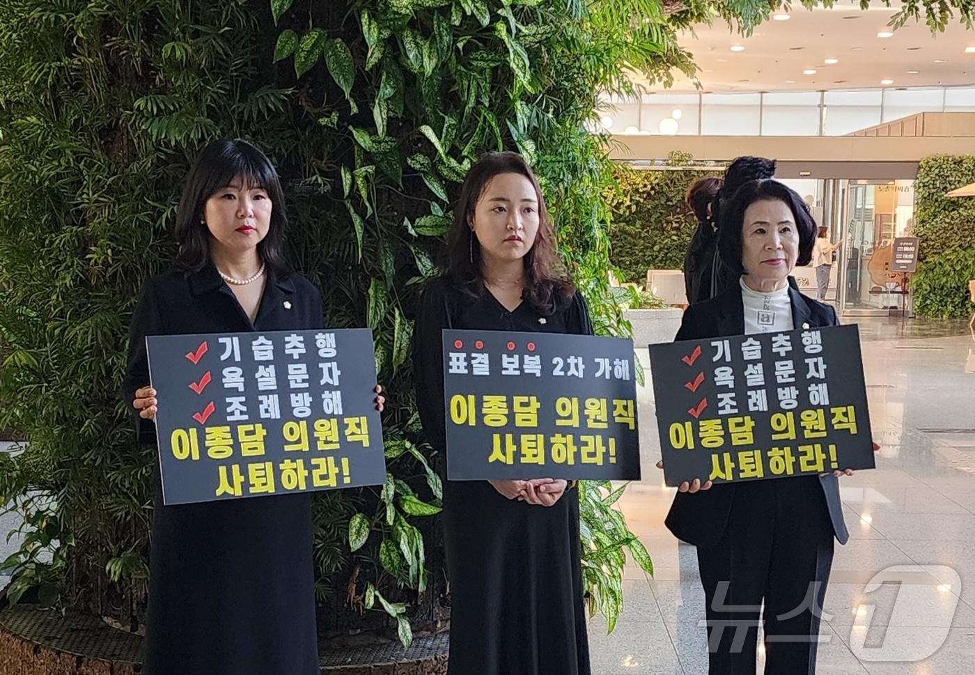 (천안=뉴스1) 이시우 기자 = 10일 천안시청 로비에서 천안시의회 여성의원들이 비속어가 담긴 문자메시지를 발송한 이종담 시의원의 사퇴를 촉구하는 피켓을 들고 서 있다.이종담 의원 …