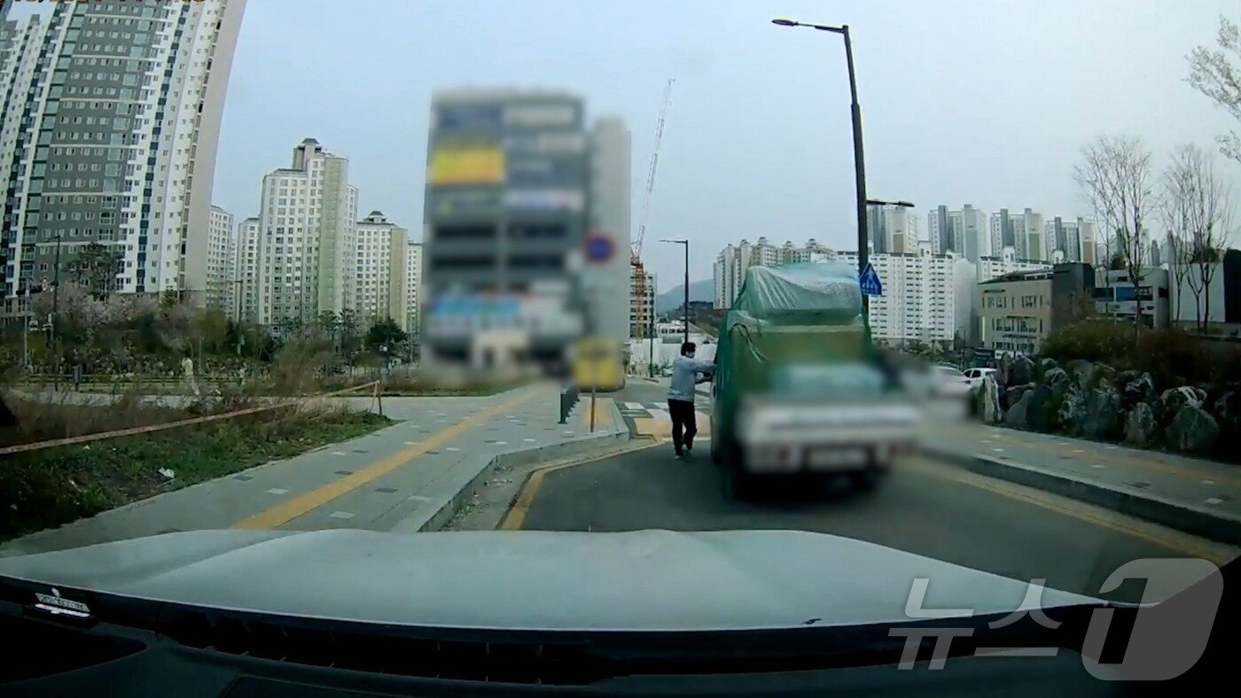 본문 이미지 - 차를 막아서는 이희성 씨.(차량 운전석 쪽).(경기남부경찰청 제공)